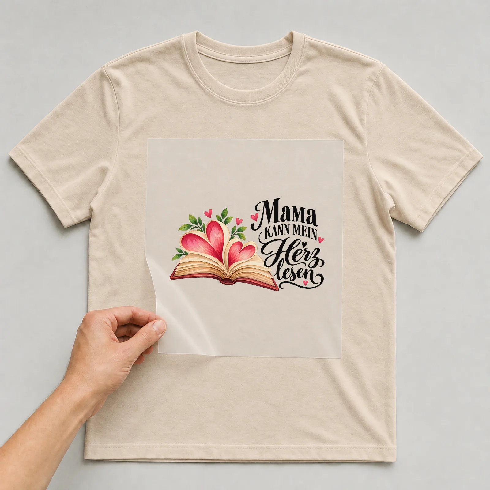Bügelbild „Mama kann mein Herz lesen“ auf beigem T-Shirt, Folie wird aufgelegt