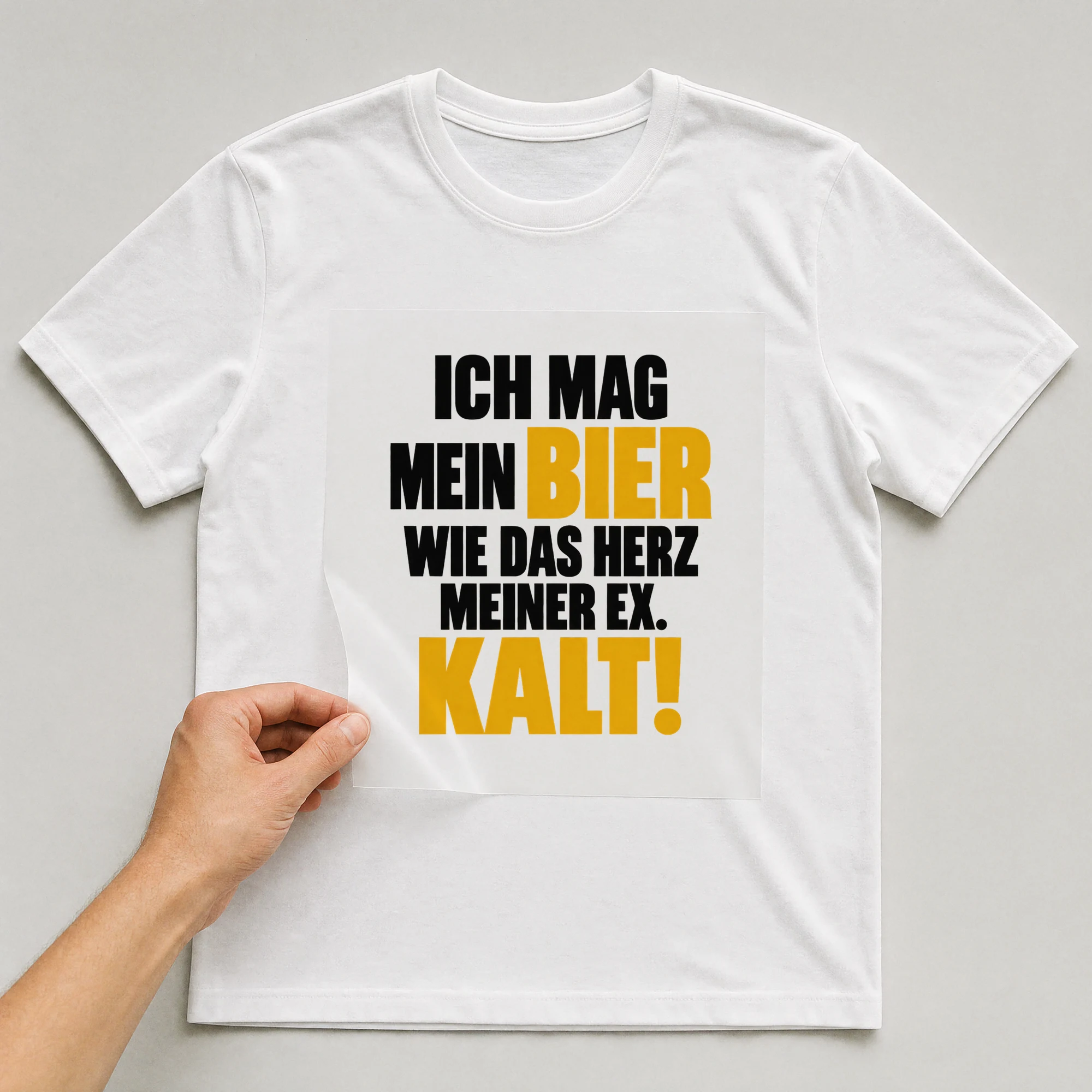 Bügelbild „Ich mag mein Bier wie das Herz meiner Ex. Kalt!“ auf weißem T-Shirt, Folie wird aufgelegt