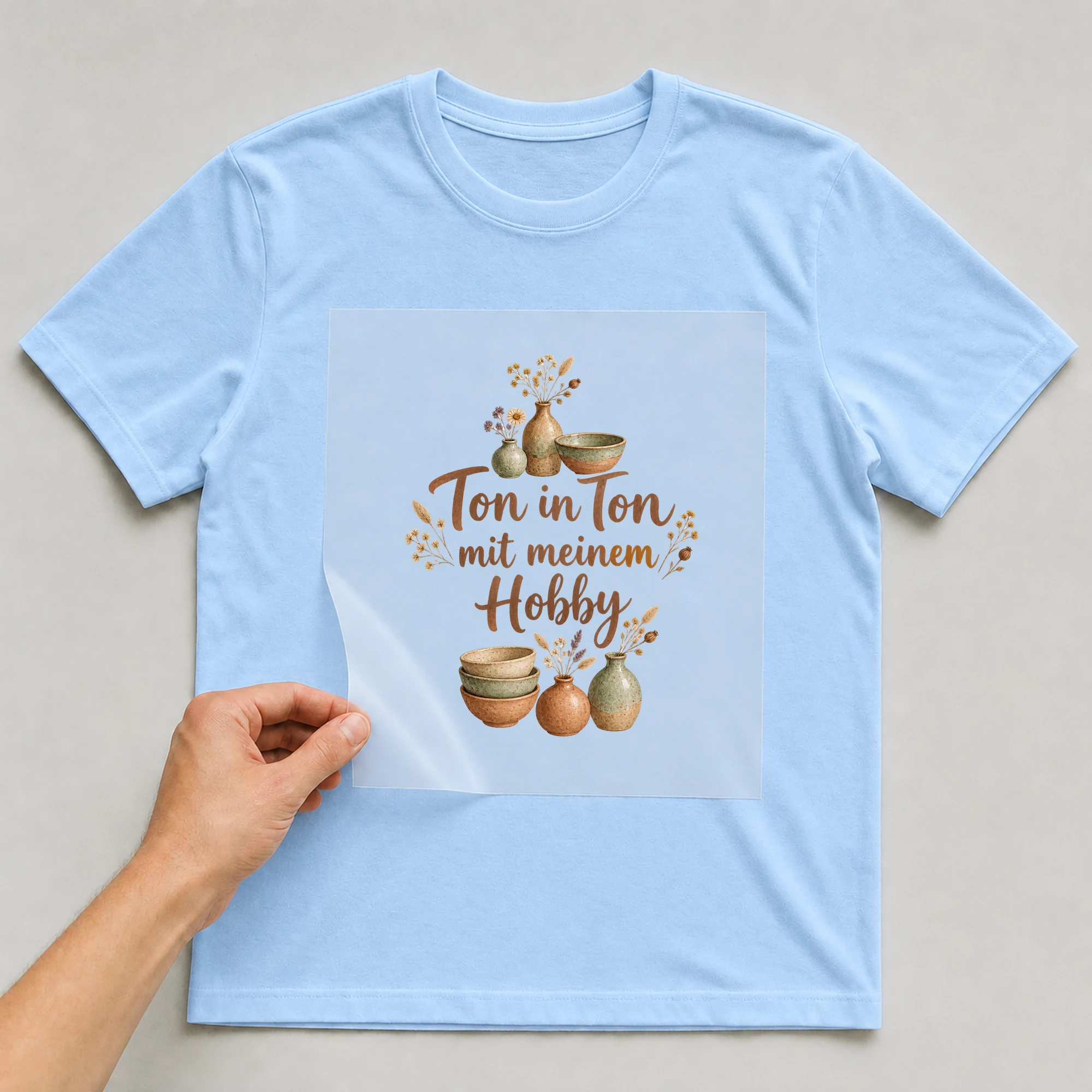 Bügelbild „Ton in Ton mit meinem Hobby“ auf babyblauem T-Shirt, Folie wird aufgelegt