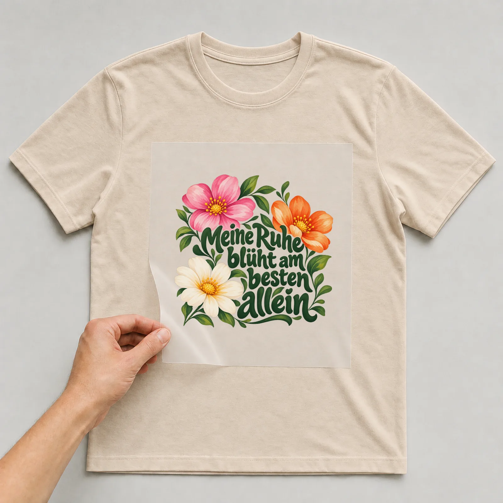 Bügelbild „Meine Ruhe blüht am besten allein“ auf beigem T-Shirt, Folie wird aufgelegt