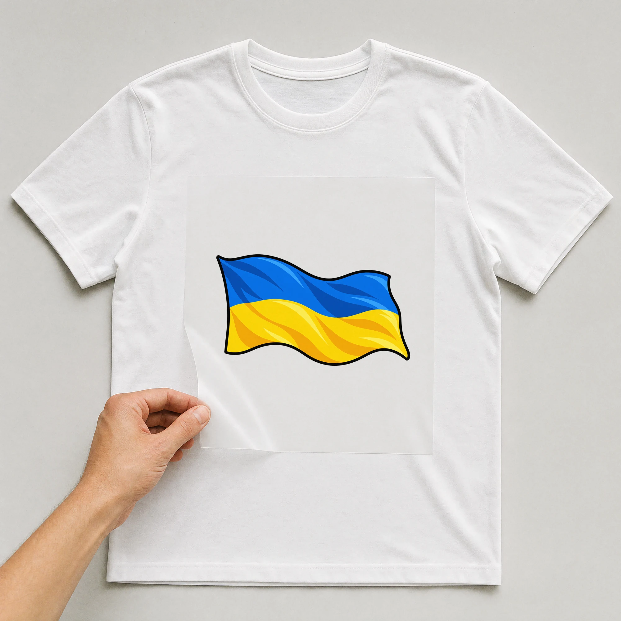 Bügelbild „Ukraine Fahne“ auf weißem T-Shirt, Folie wird aufgelegt