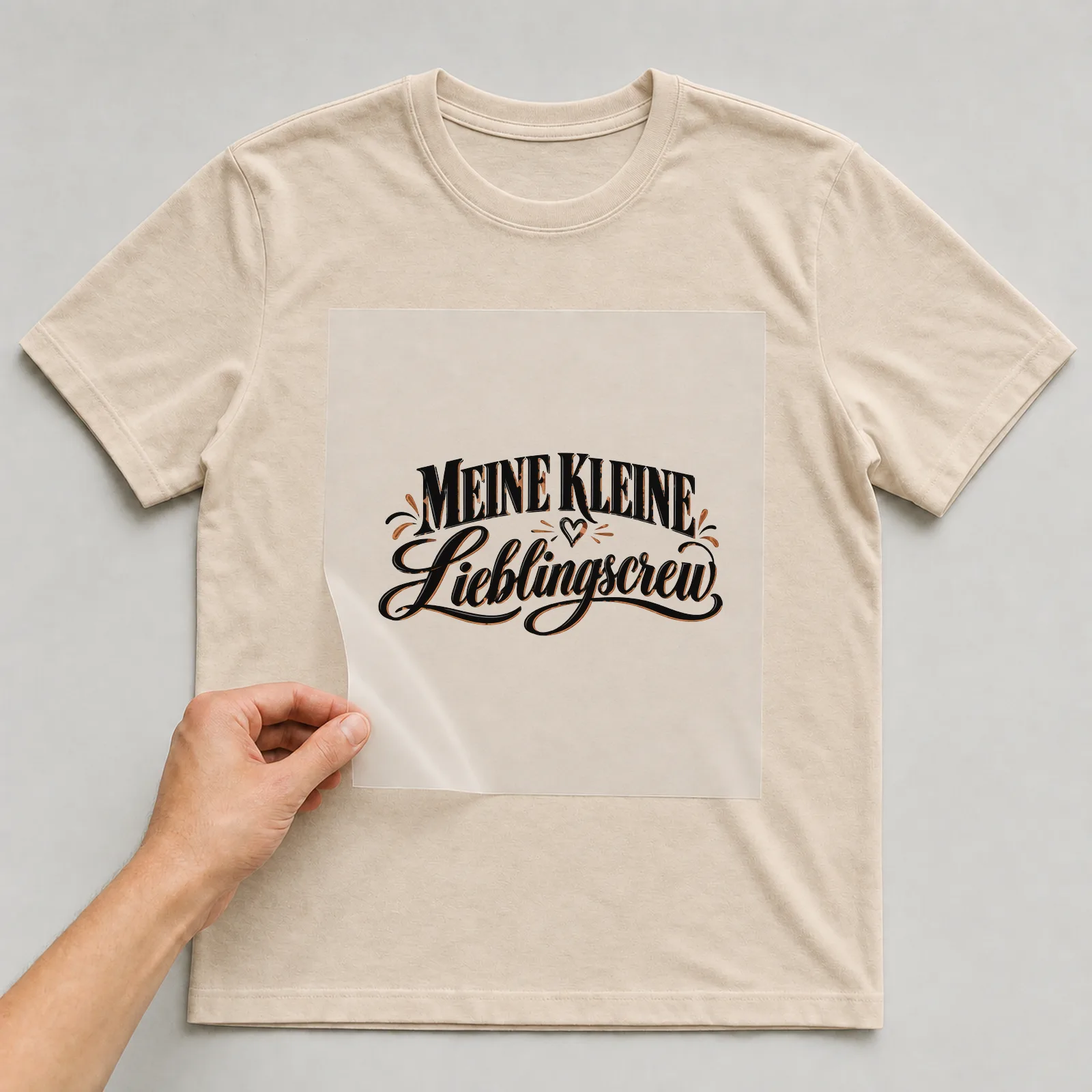 Bügelbild „Meine kleine Lieblingscrew“ auf beigem T-Shirt, Folie wird aufgelegt