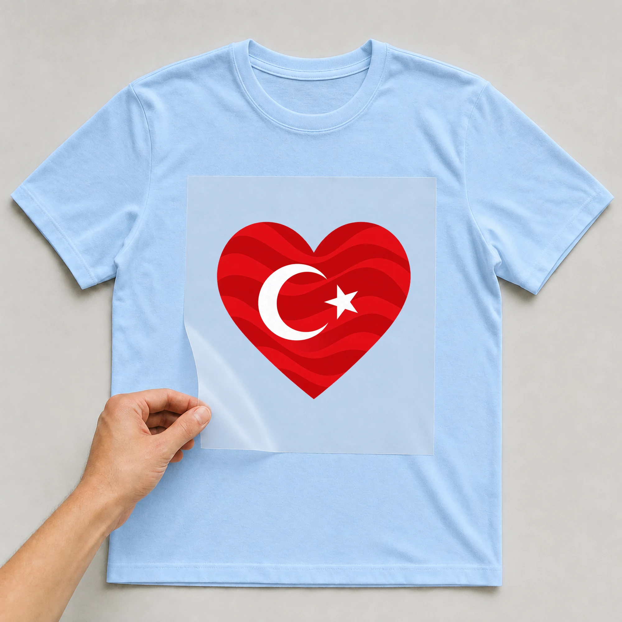 Bügelbild „Herz-Flagge Türkei“ auf babyblauem T-Shirt, Folie wird aufgelegt
