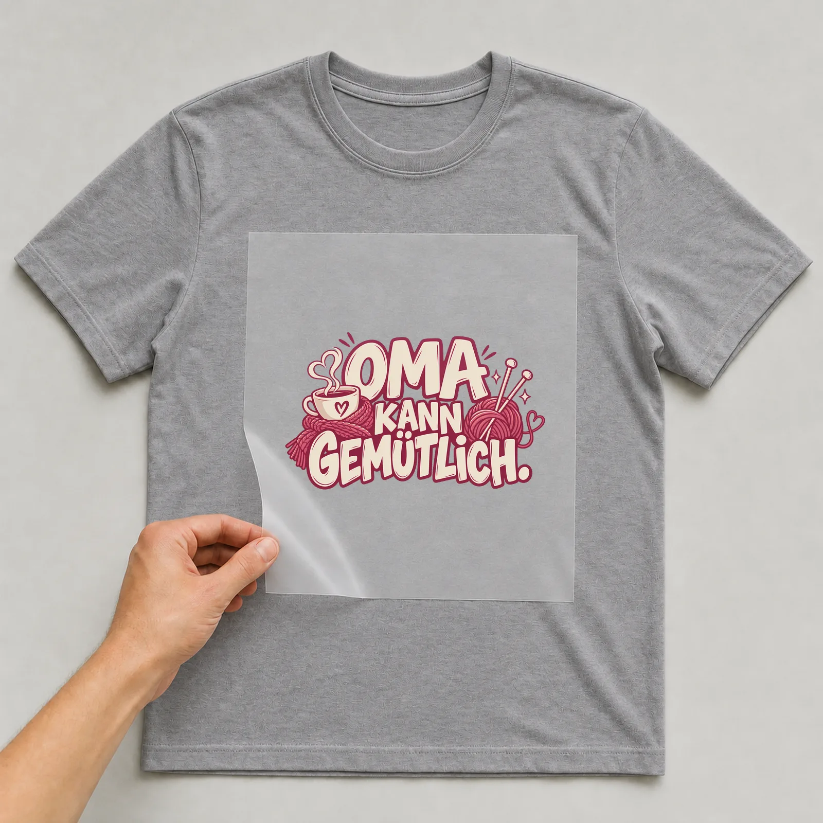 Bügelbild „Oma kann gemütlich“ auf grauem T-Shirt, Folie wird aufgelegt