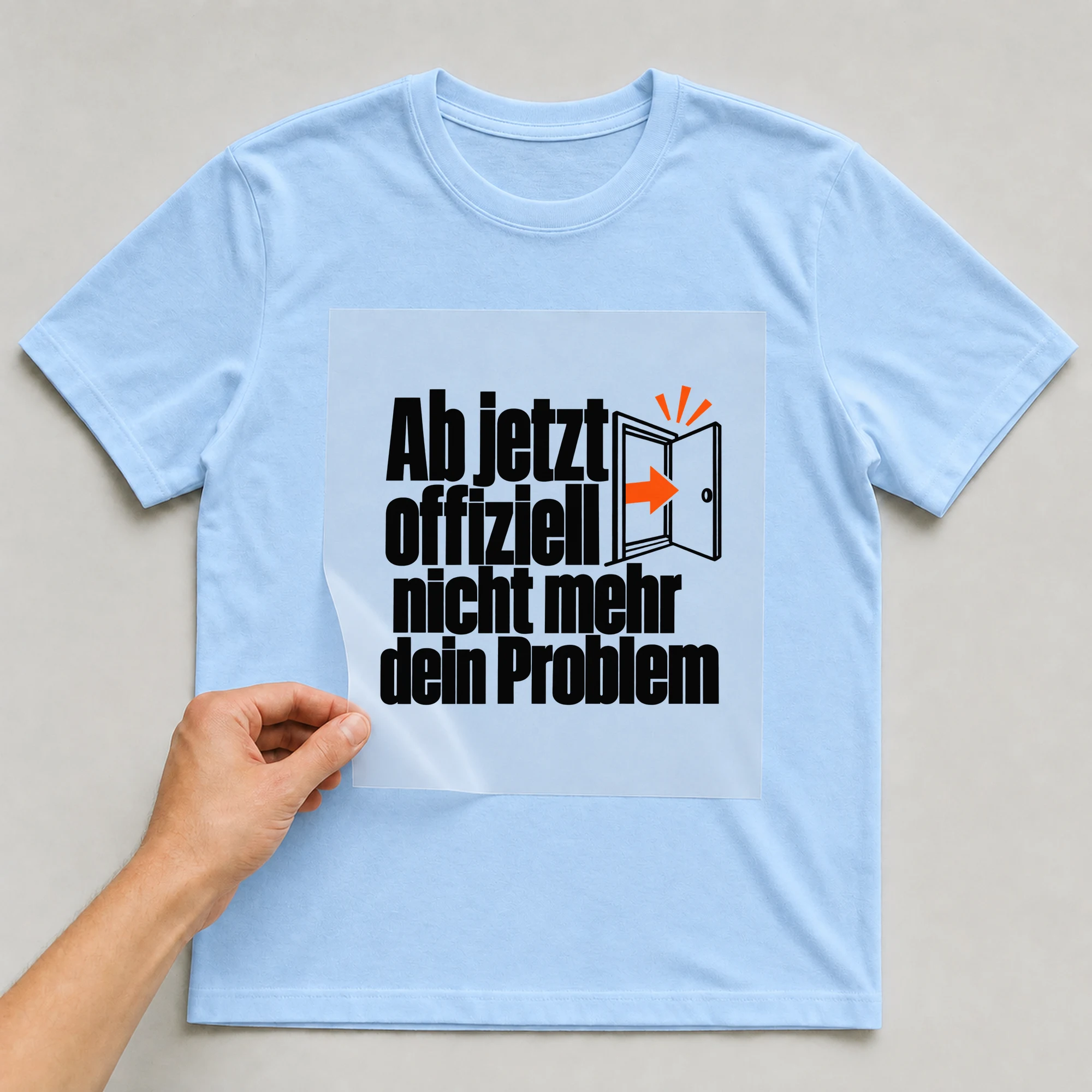 Bügelbild „Ab jetzt offiziell nicht mehr dein Problem“ auf babyblauem T-Shirt, Folie wird aufgelegt