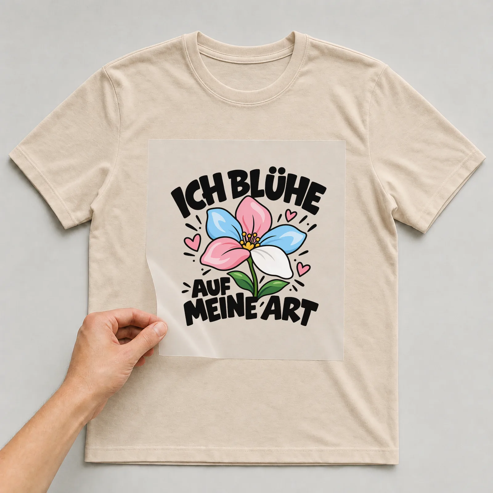 Bügelbild „Ich blühe auf meine Art“ auf beigem T-Shirt, Folie wird aufgelegt