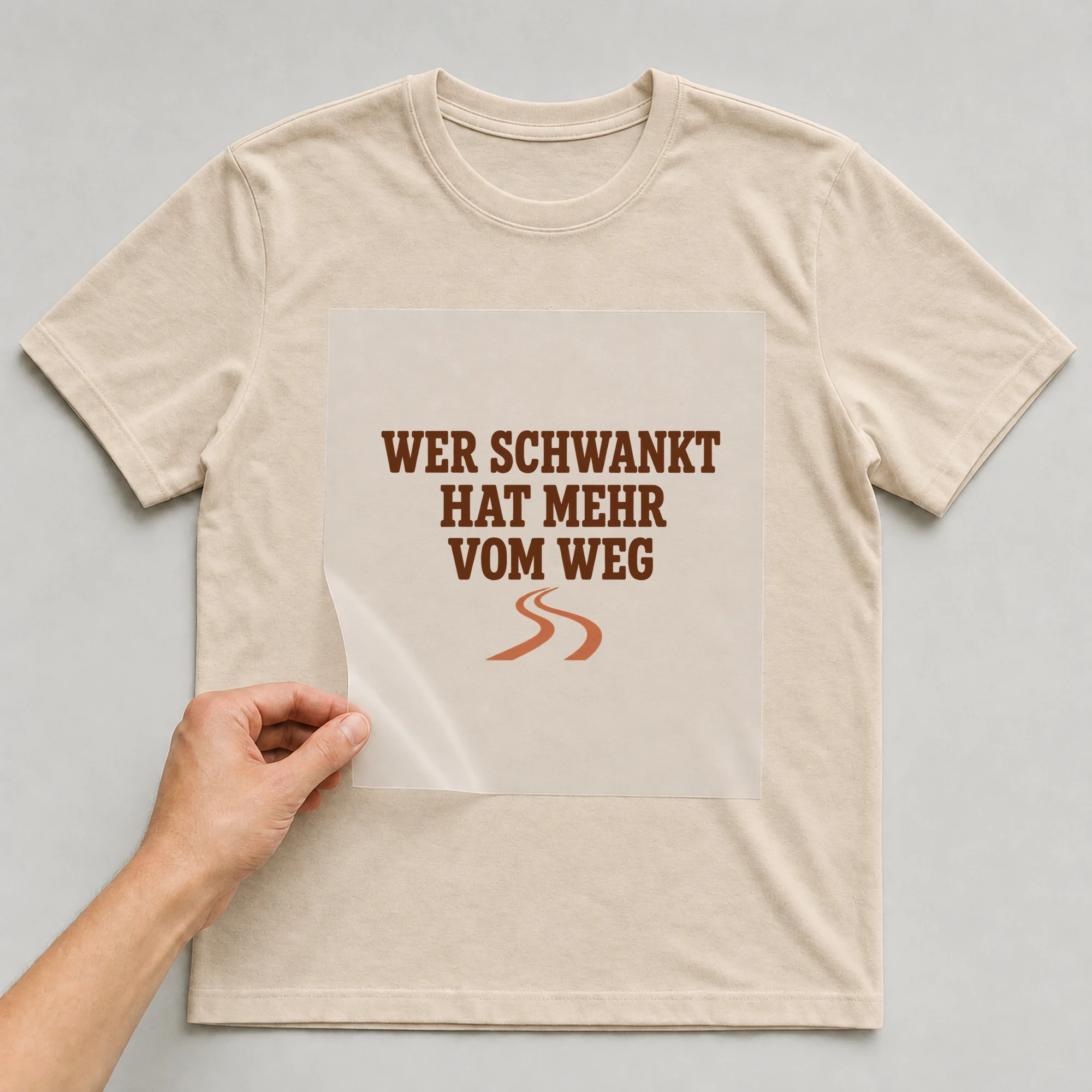 Bügelbild „WER SCHWANKT HAT MEHR VOM WEG“ auf beigem T-Shirt, Folie wird aufgelegt