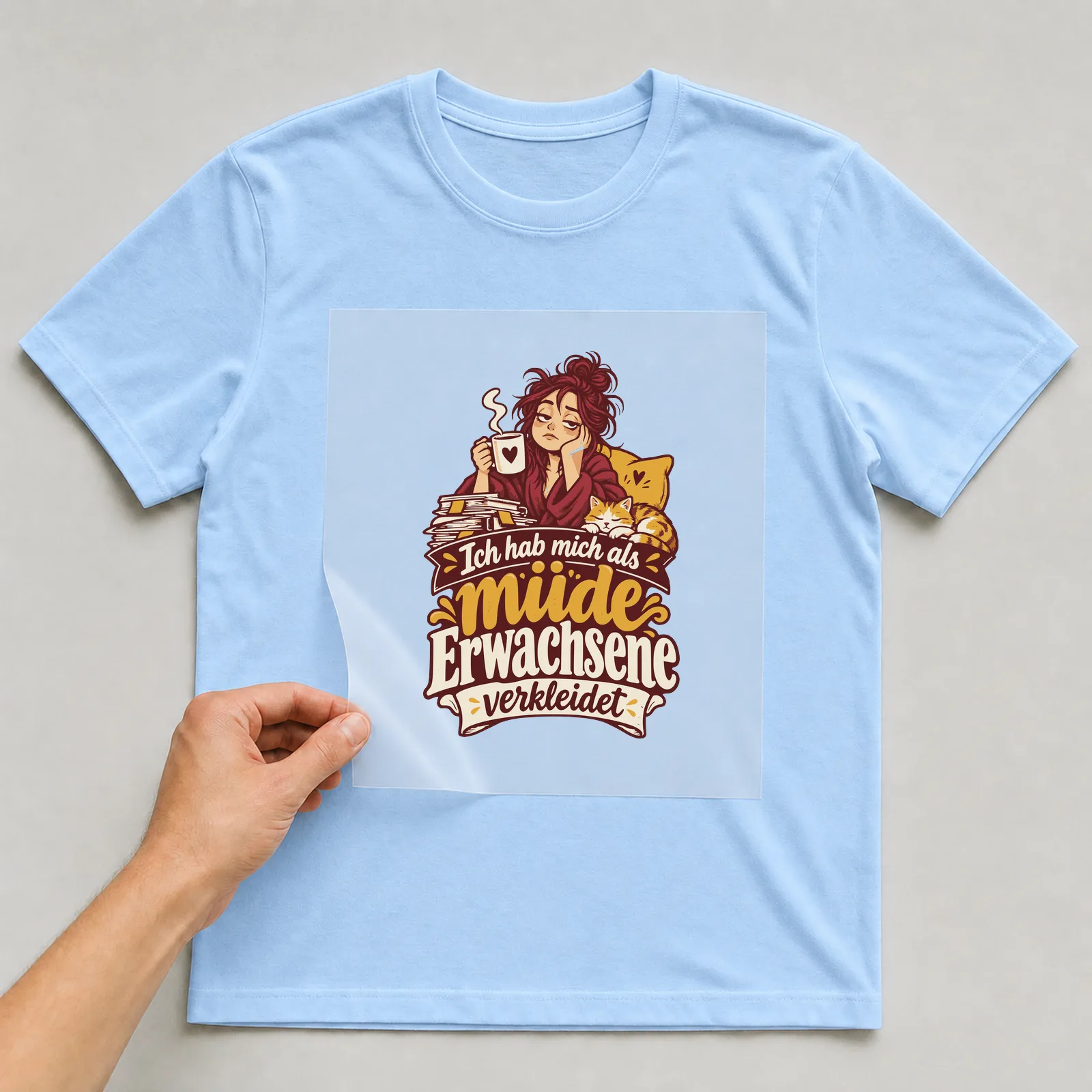 Bügelbild Ich hab mich als müde Erwachsene verkleidet auf hellblauem T-Shirt, Folie wird aufgelegt