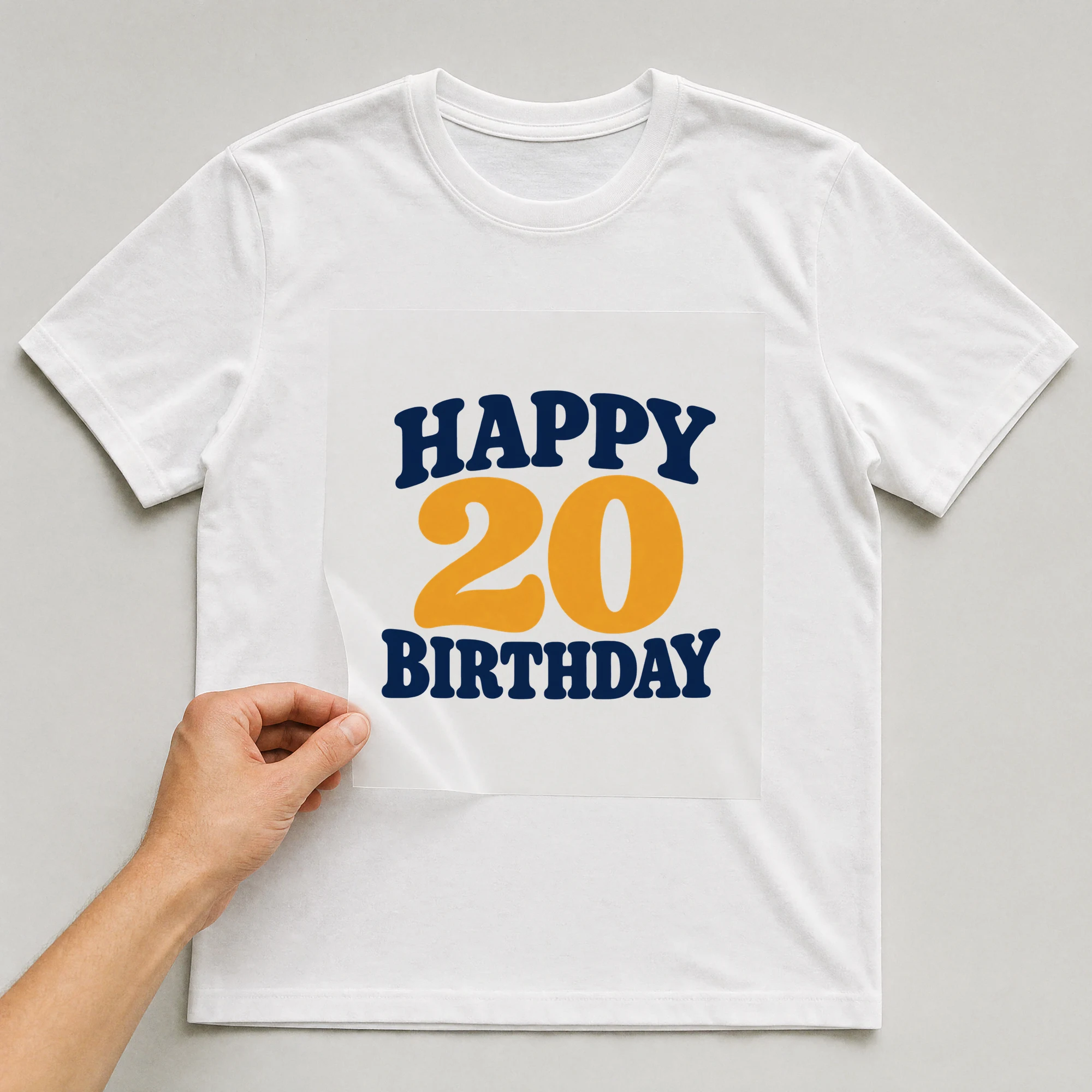 Bügelbild „Happy 20 Birthday“ auf weißem T-Shirt, Folie wird aufgelegt