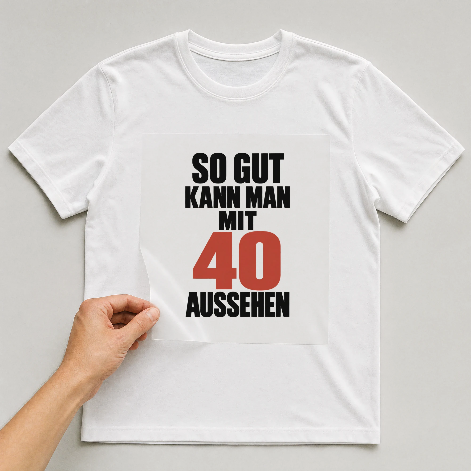 Bügelbild „So gut kann man mit 40 aussehen“ auf weißem T-Shirt, Folie wird aufgelegt
