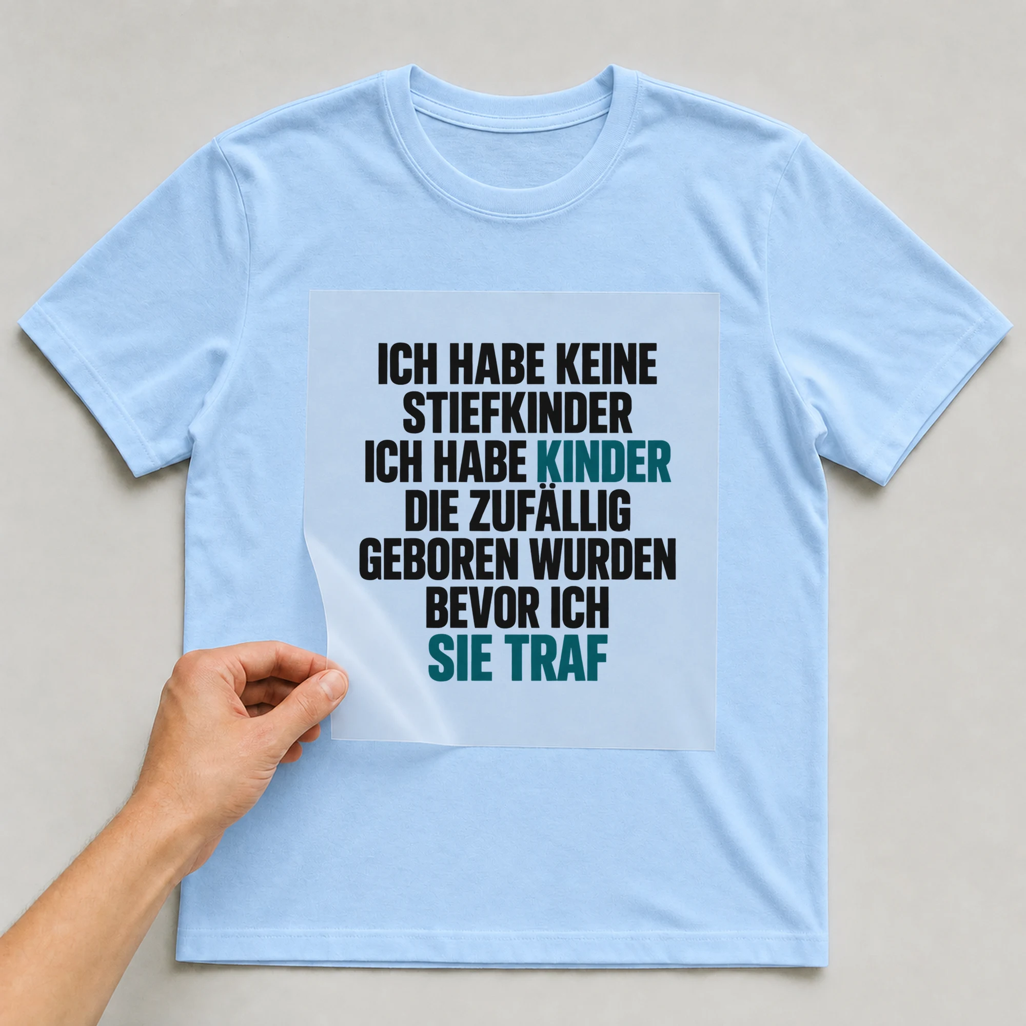 Bügelbild „Ich habe keine Stiefkinder ich habe Kinder die zufällig geboren wurden bevor“ auf babyblauem T-Shirt, Folie wird aufgelegt