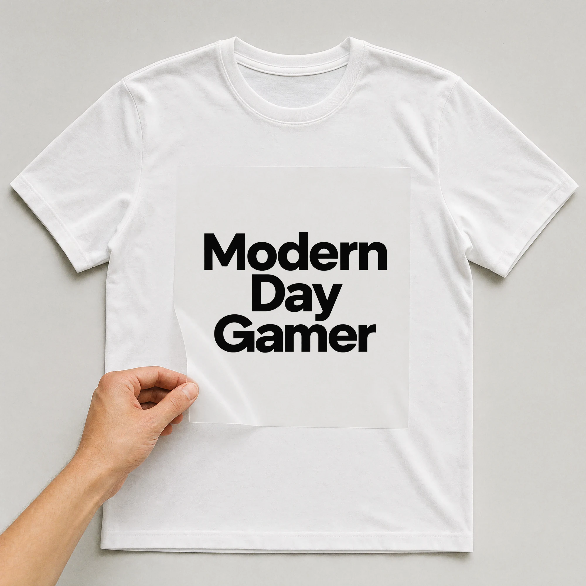 Bügelbild „Modern Day Gamer“ auf weißem T-Shirt, Folie wird aufgelegt