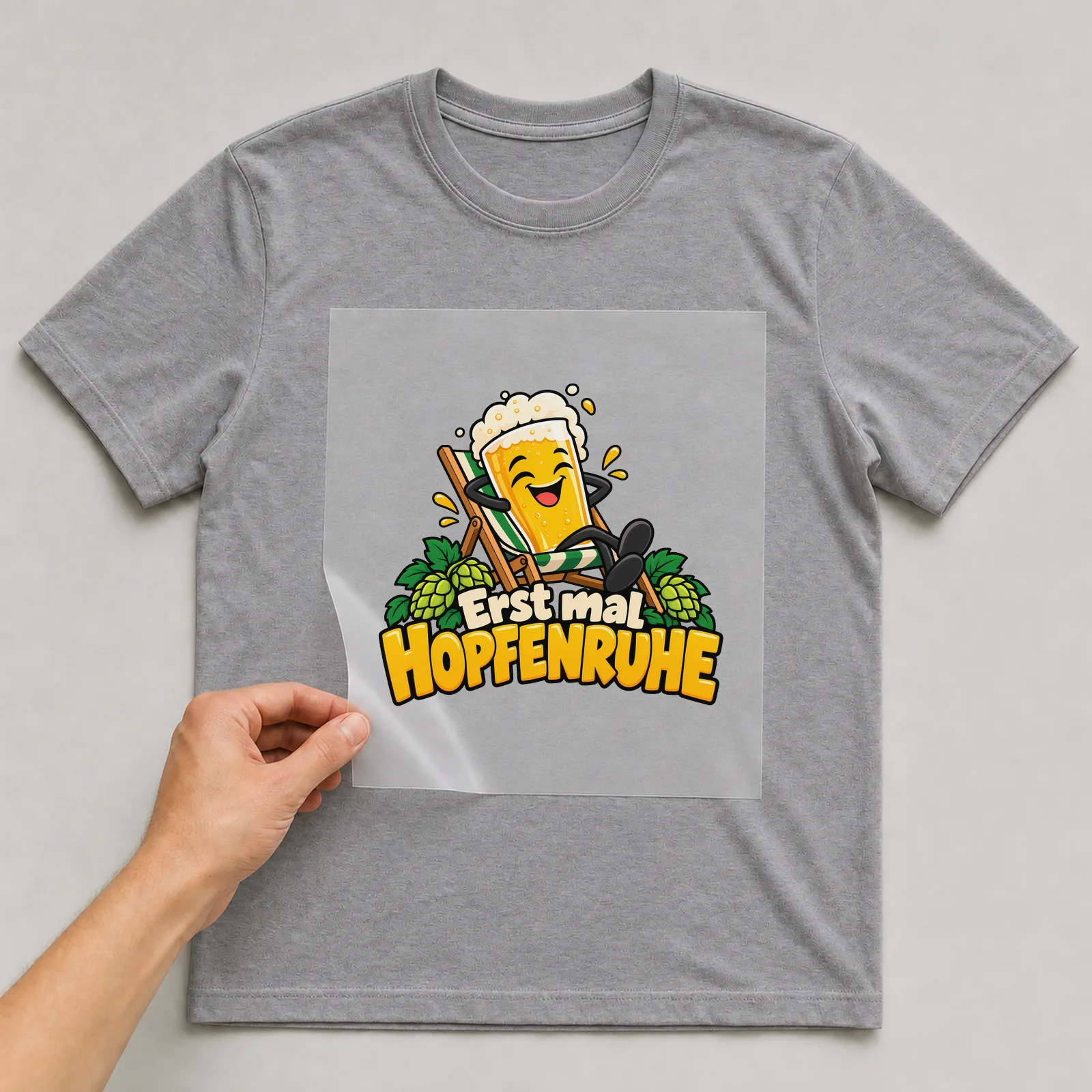 Bügelbild „Erst mal Hopfenruhe“ auf grauem T-Shirt, Folie wird aufgelegt