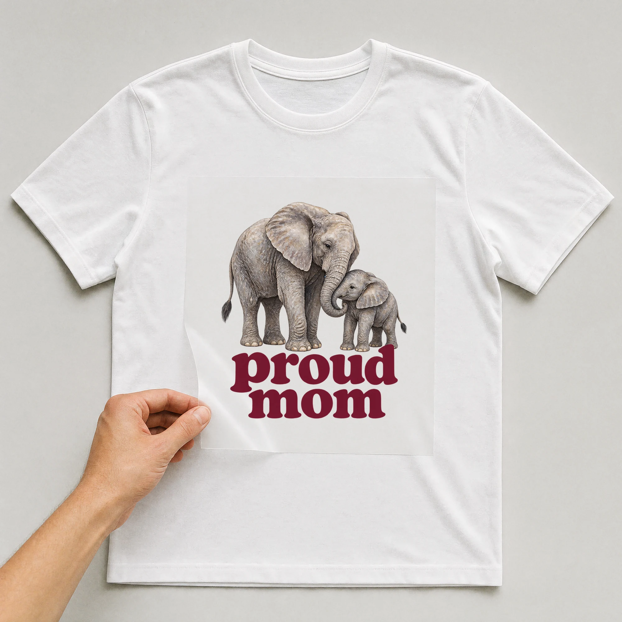 Bügelbild „proud mom“ auf weißem T-Shirt, Folie wird aufgelegt