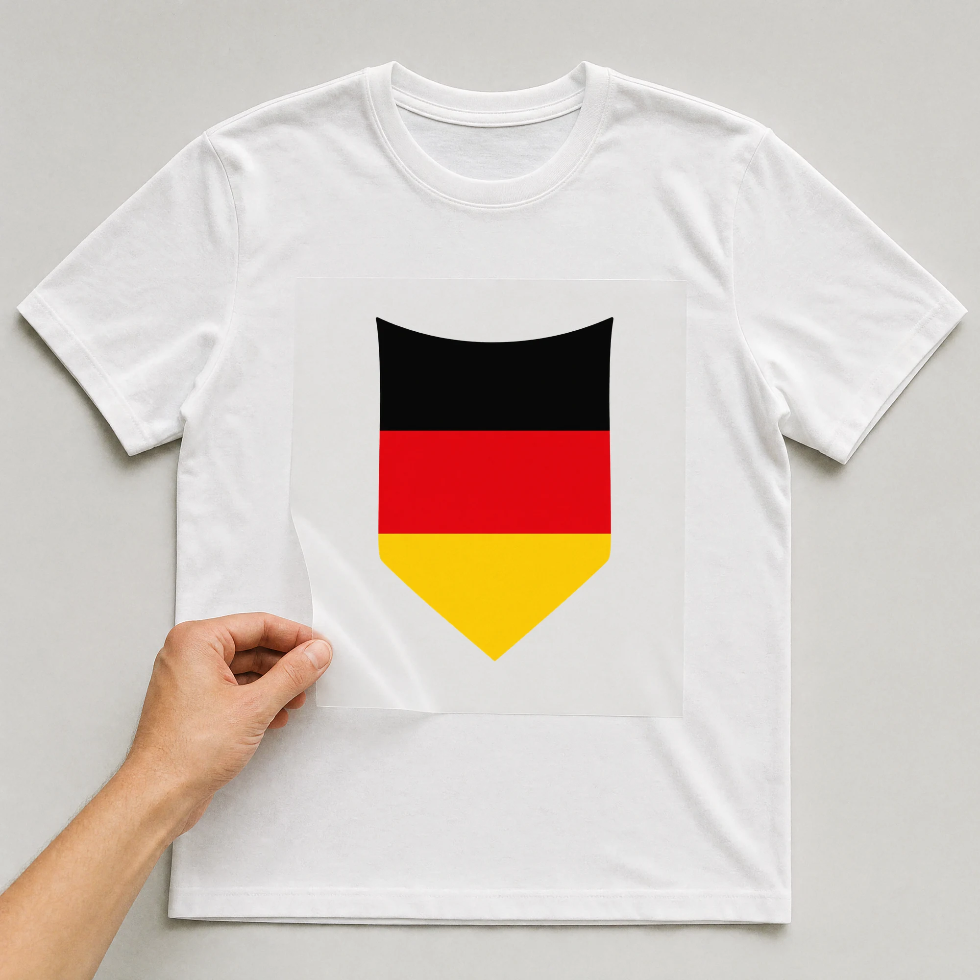 Bügelbild „Deutschland Fahne Wimpel“ auf weißem T-Shirt, Folie wird aufgelegt