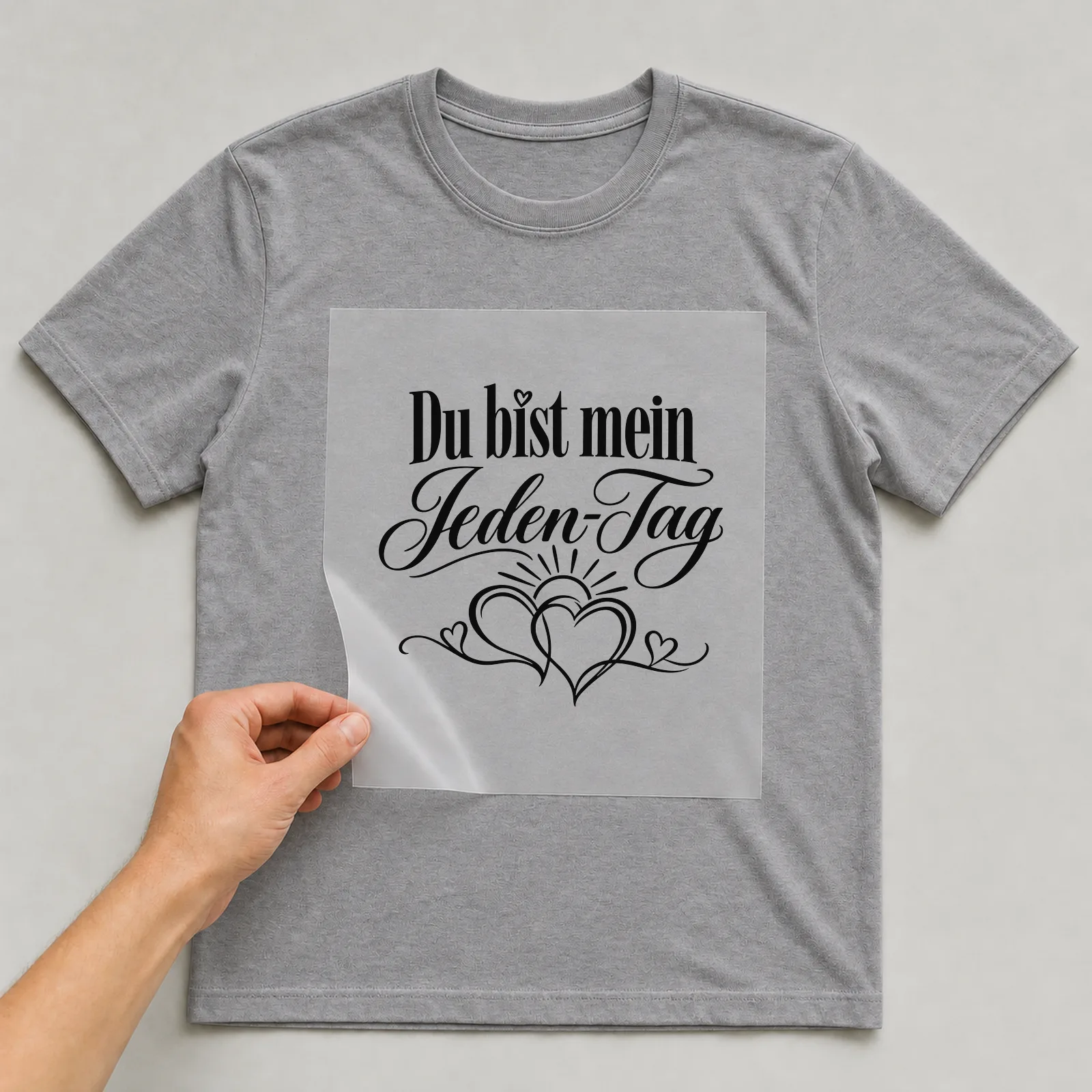 Bügelbild „Du bist mein Jeden-Tag“ auf grauem T-Shirt, Folie wird aufgelegt