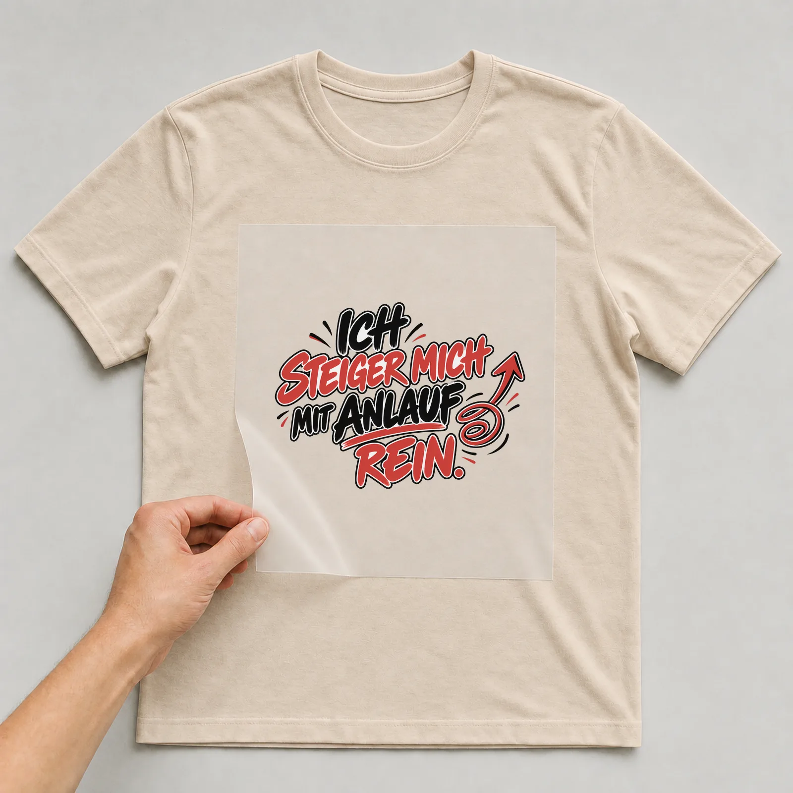Bügelbild „Ich steiger mich mit Anlauf rein“ auf beigem T-Shirt, Folie wird aufgelegt