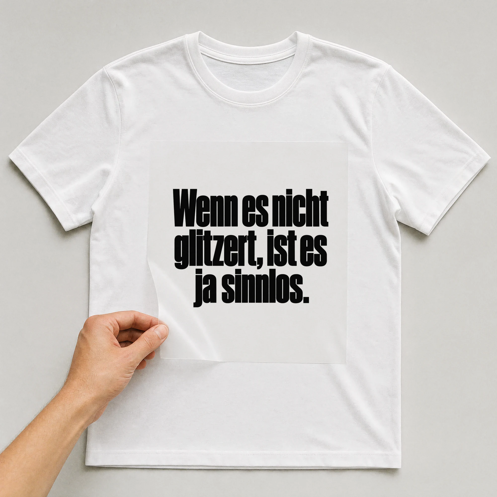 Bügelbild „Wenn es nicht glitzert, ist es ja sinnlos.“ auf weißem T-Shirt, Folie wird aufgelegt