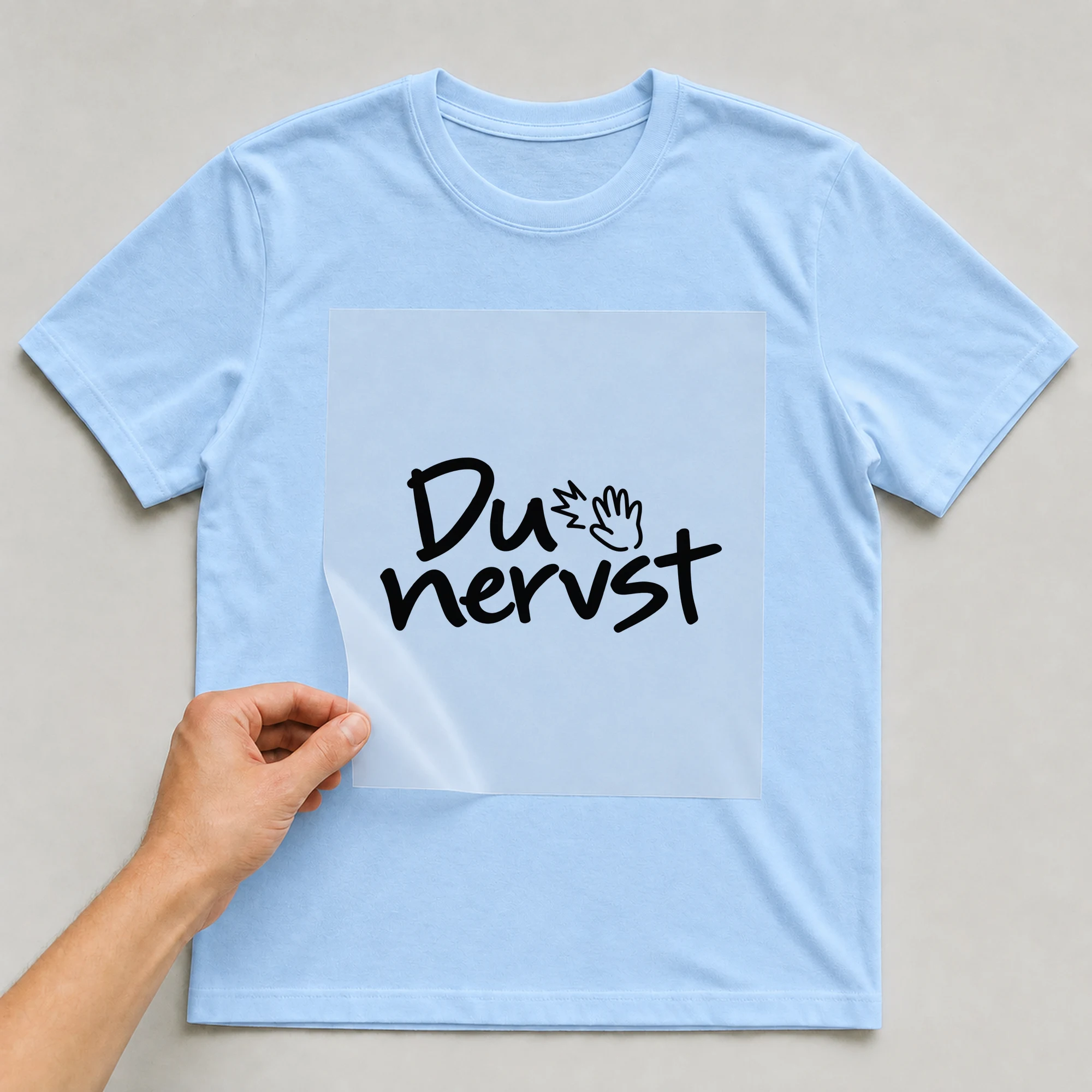 Bügelbild „Du nervst“ auf babyblauem T-Shirt, Folie wird aufgelegt
