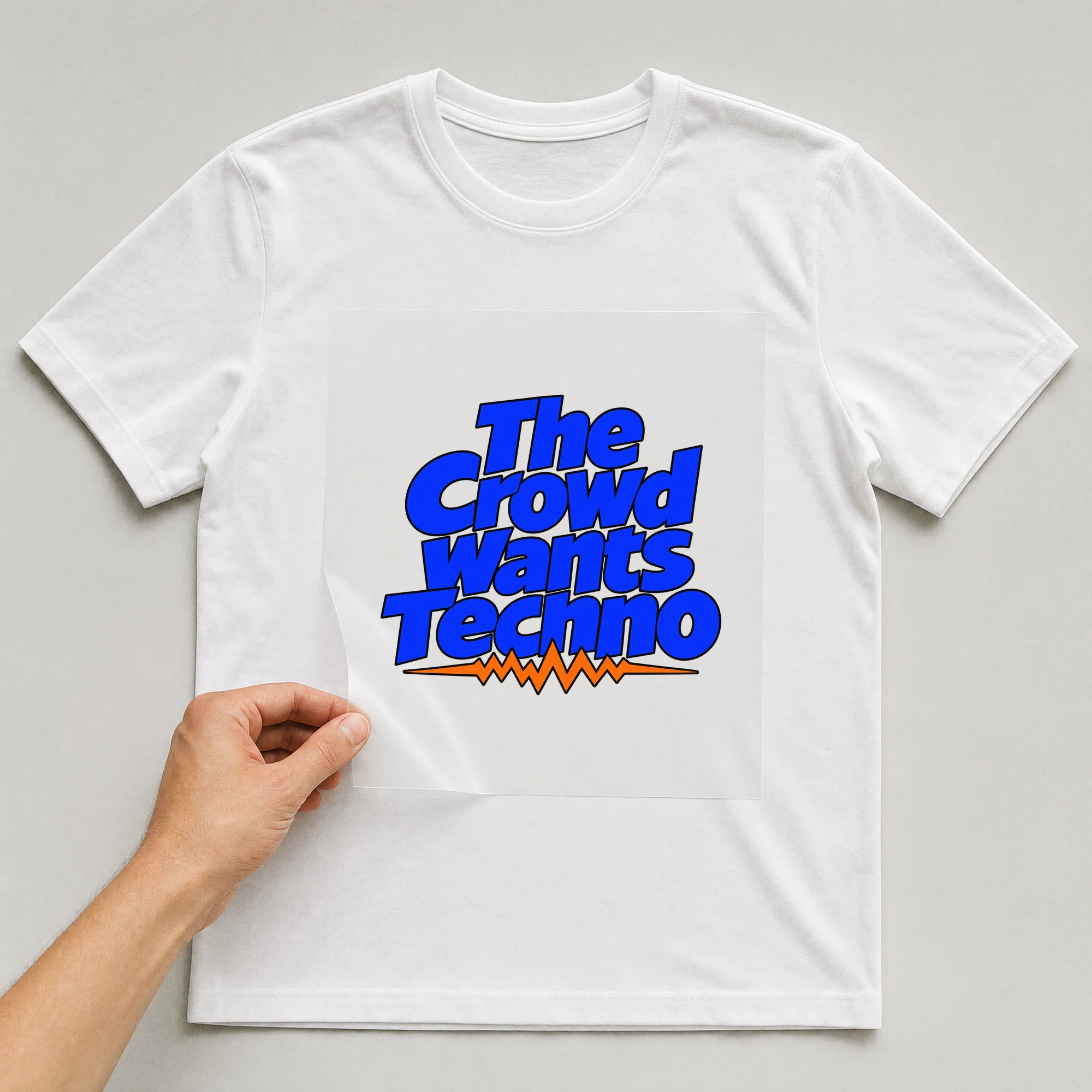 Bügelbild „The Crowd Wants Techno“ auf weißem T-Shirt, Folie wird aufgelegt