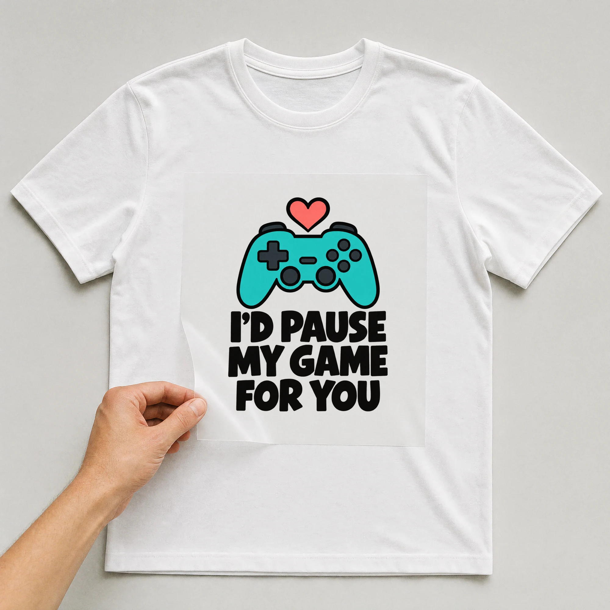 Bügelbild „I'd Pause My Game For You“ auf weißem T-Shirt, Folie wird aufgelegt