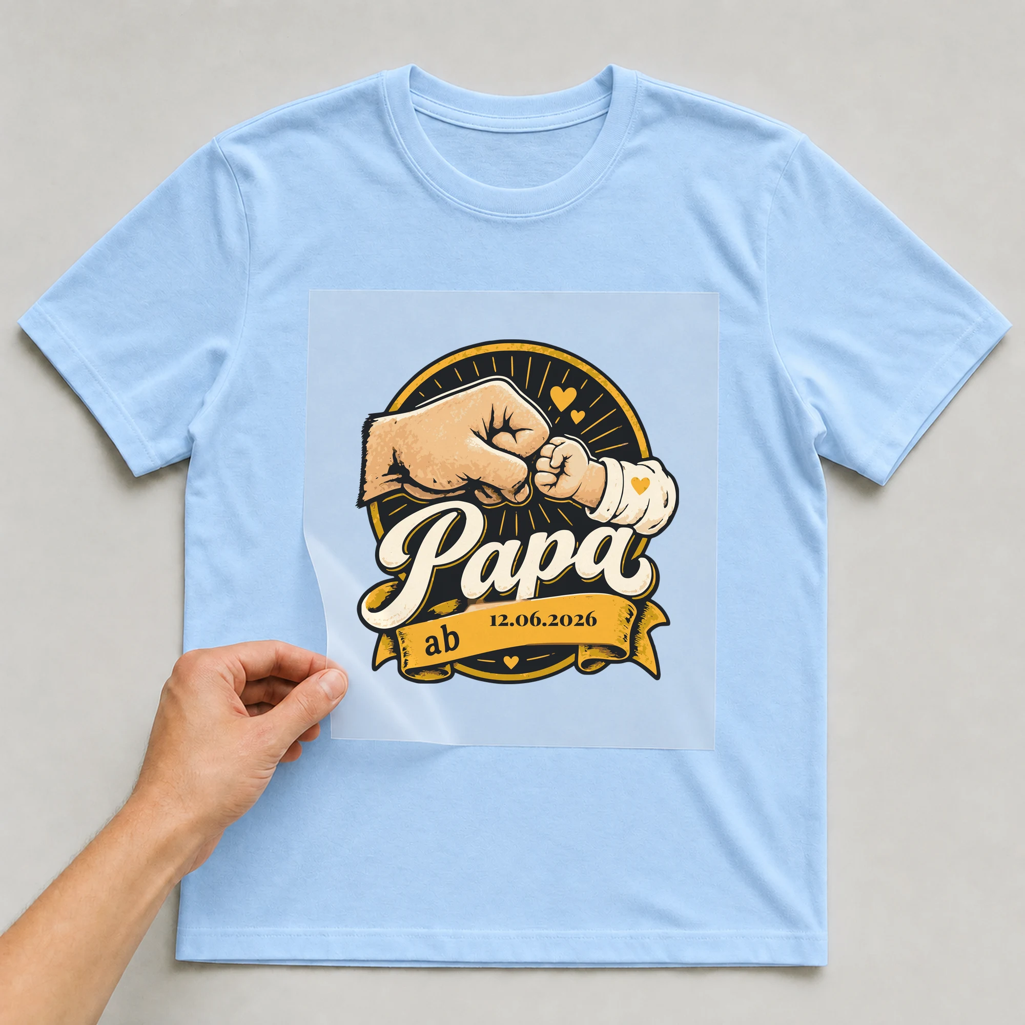 Bügelbild Papa ab mit Datum auf hellblauem T-Shirt, Folie wird aufgelegt