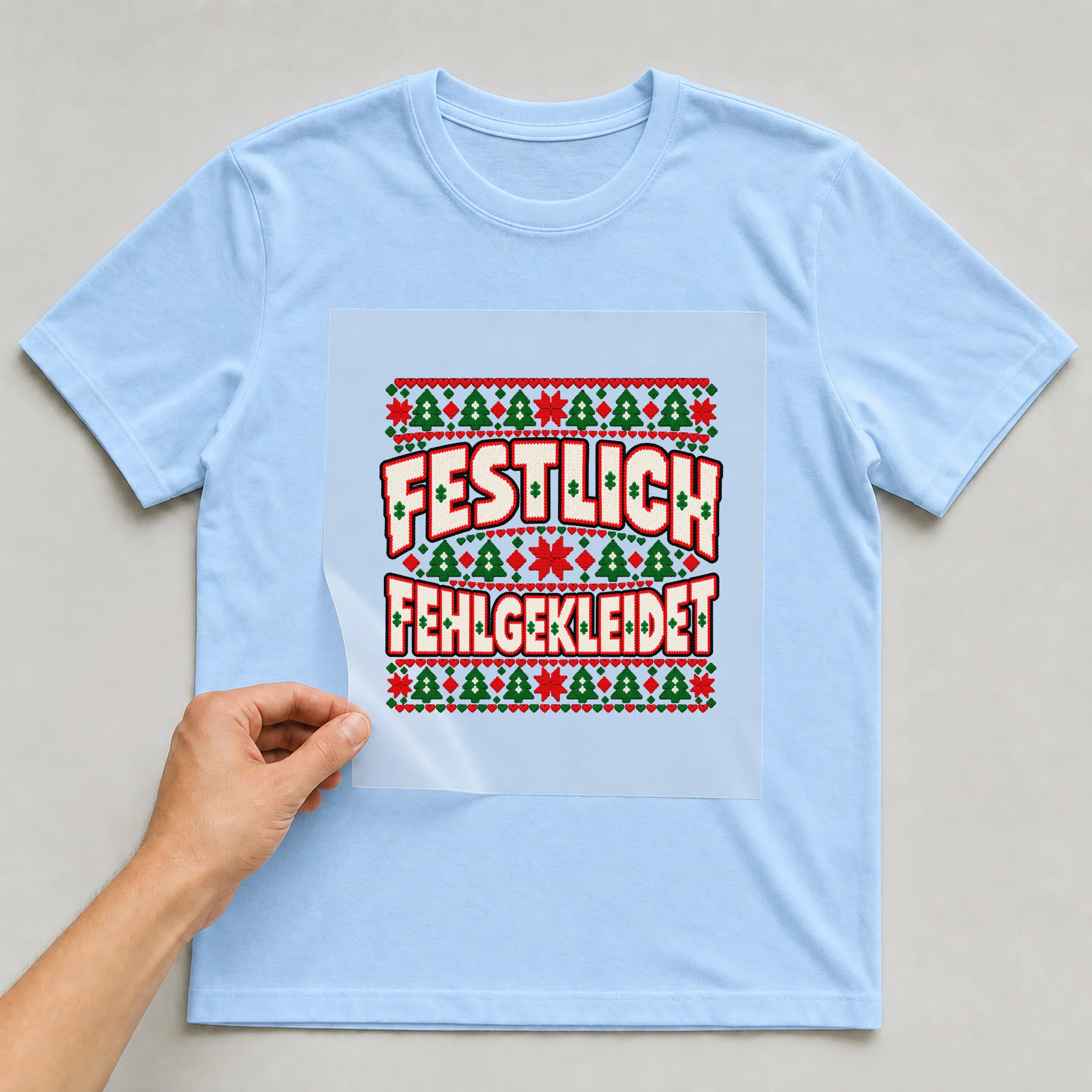 Bügelbild Festlich fehlgekleidet (Strickmuster) auf hellblauem T-Shirt, Folie wird aufgelegt