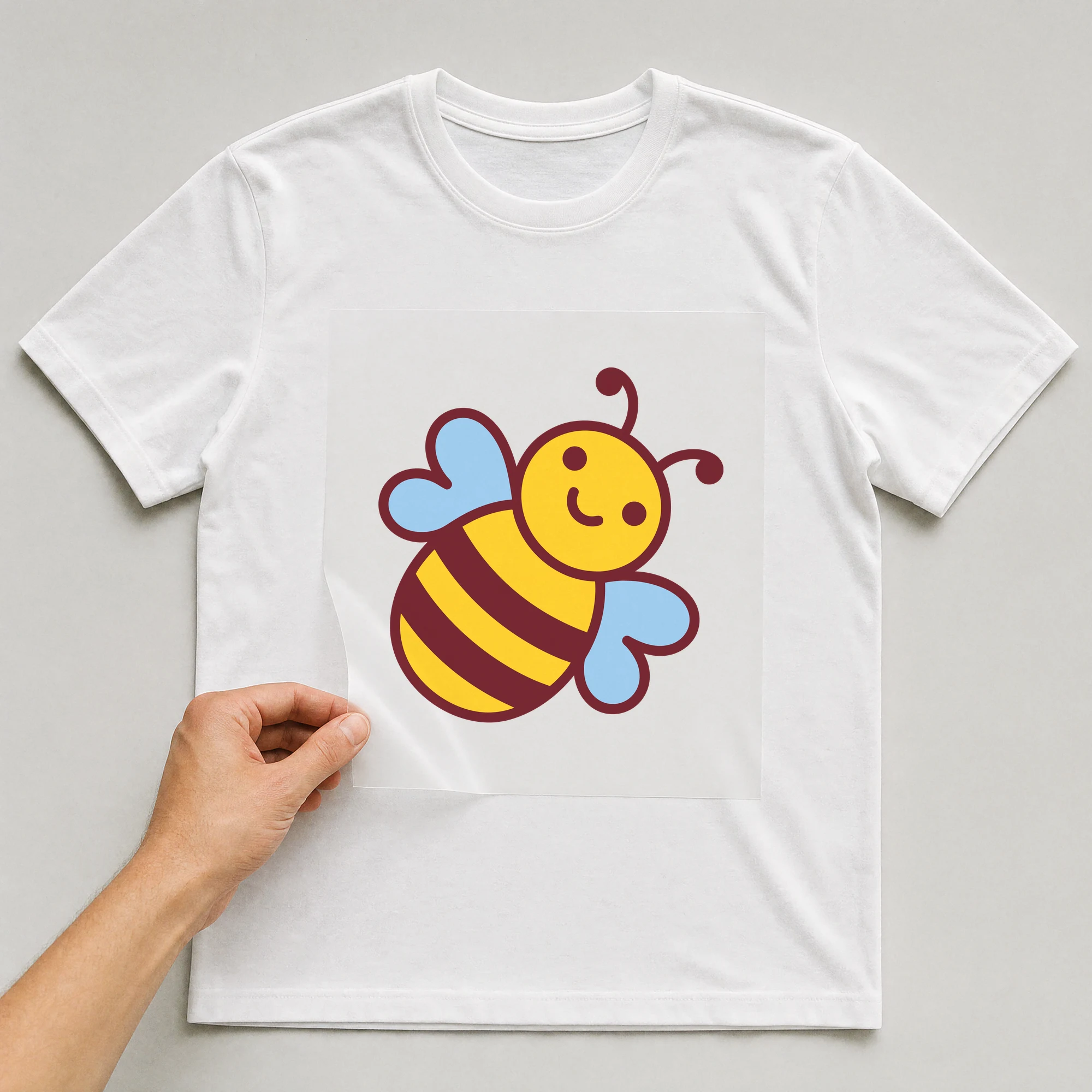 Bügelbild „Biene“ auf weißem T-Shirt, Folie wird aufgelegt