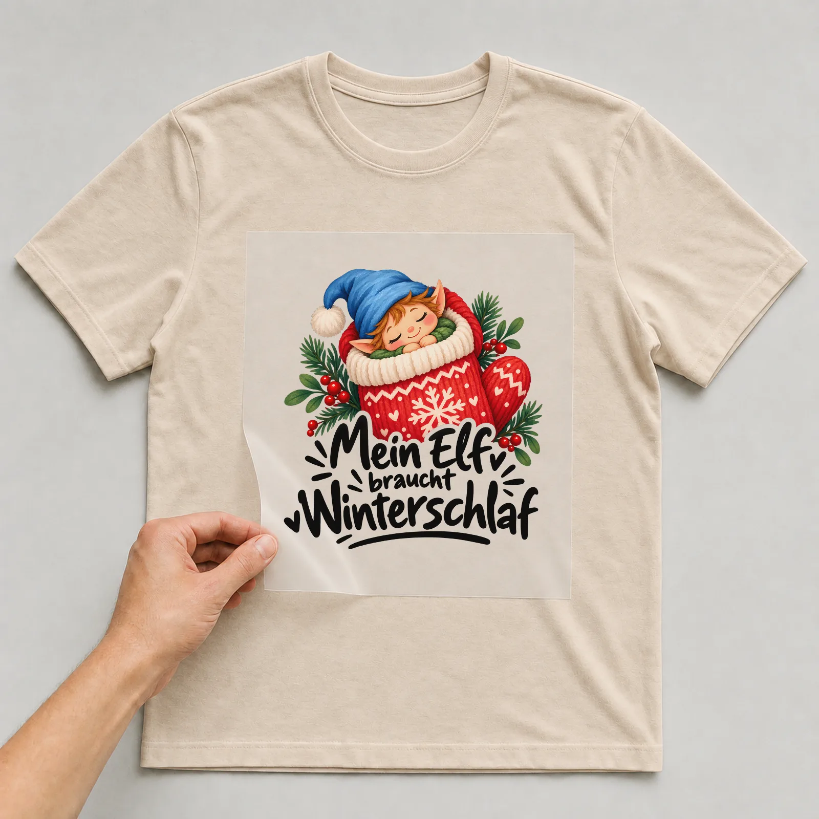 Bügelbild „Mein Elf braucht Winterschlaf“ auf beigem T-Shirt, Folie wird aufgelegt