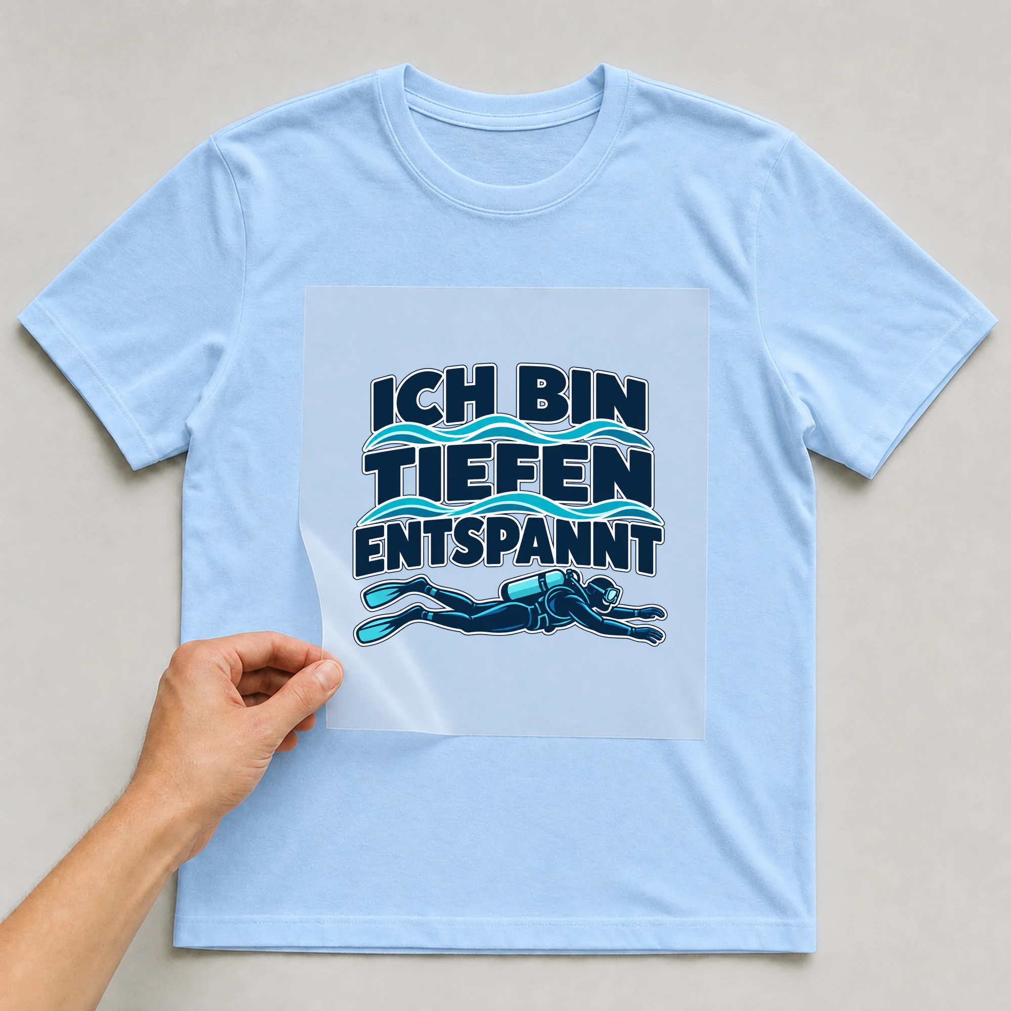 Bügelbild „ICH BIN TIEFEN ENTSPANNT“ auf babyblauem T-Shirt, Folie wird aufgelegt