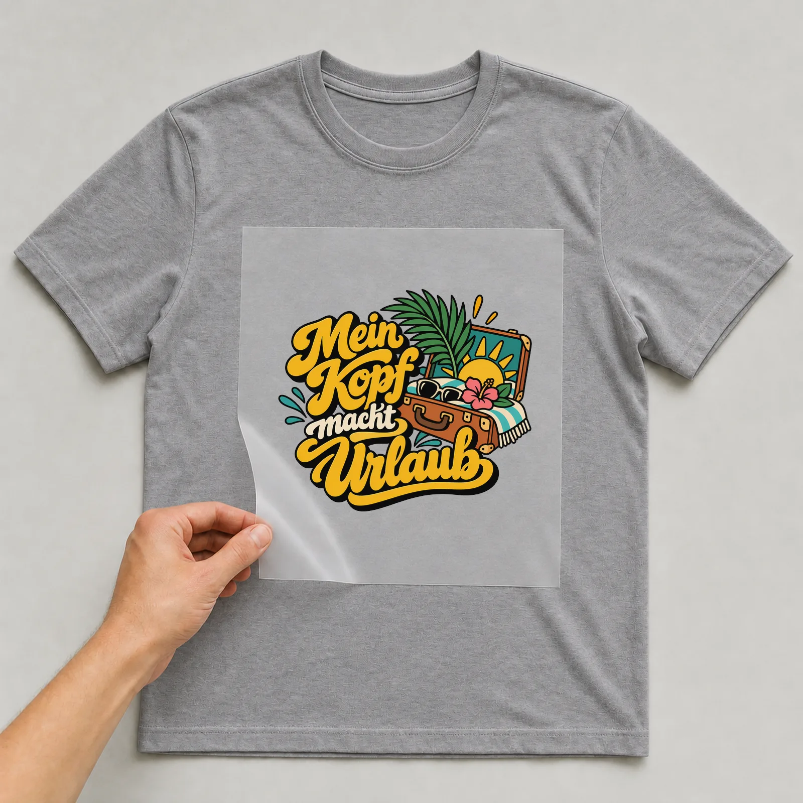 Bügelbild „Mein Kopf macht Urlaub“ auf grauem T-Shirt, Folie wird aufgelegt