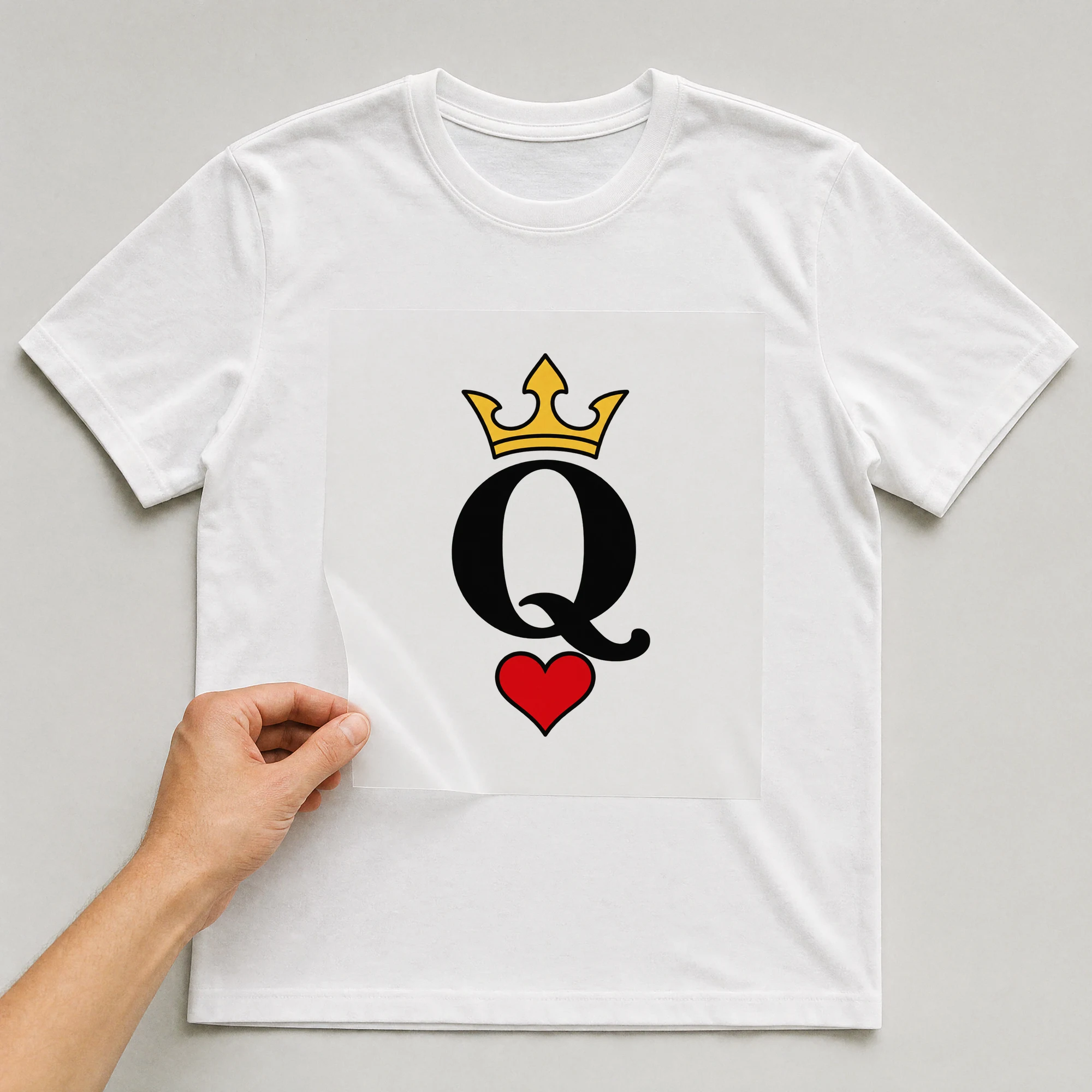 Bügelbild „Q“ auf weißem T-Shirt, Folie wird aufgelegt