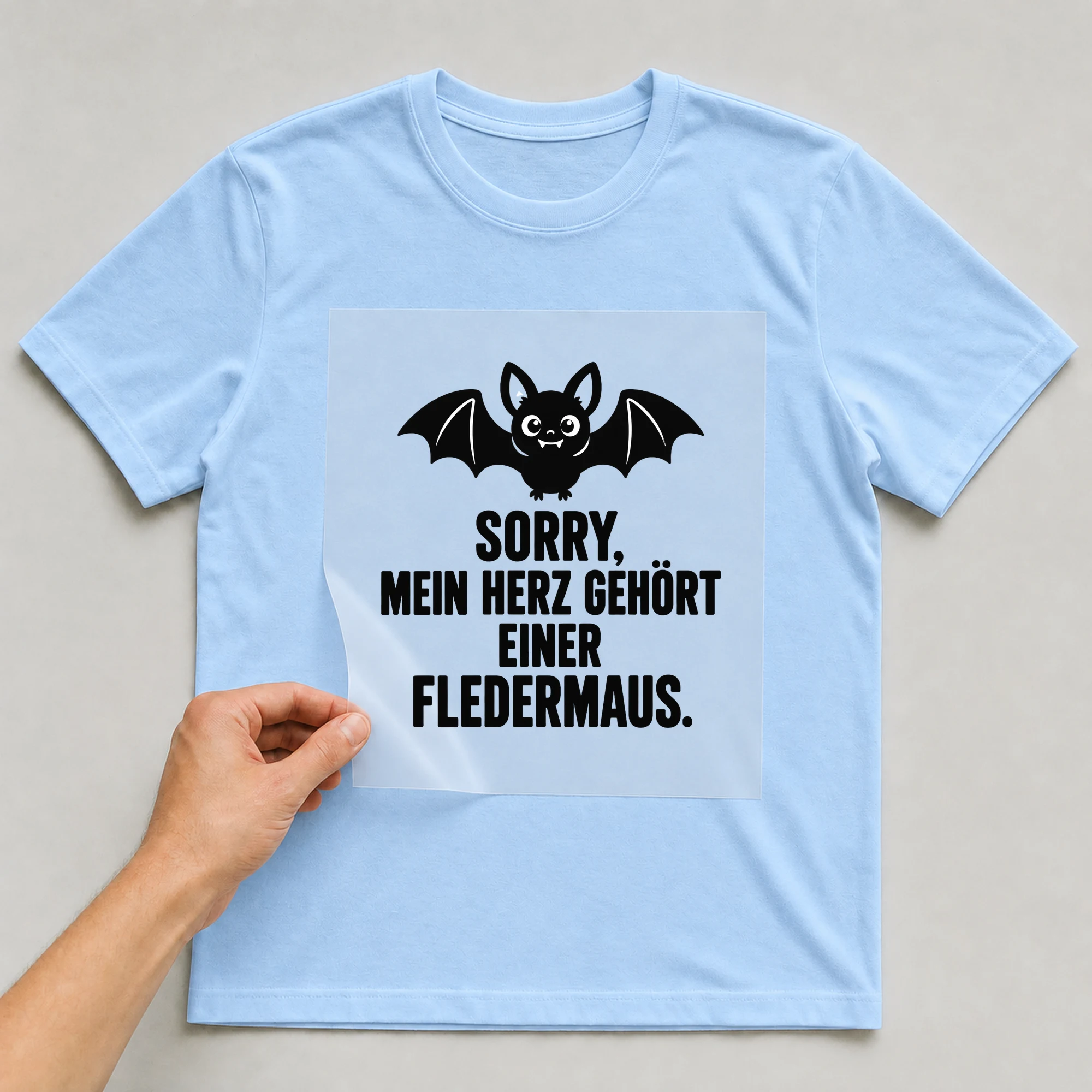Bügelbild „Sorry, mein Herz gehört einer Fledermaus.“ auf babyblauem T-Shirt, Folie wird aufgelegt