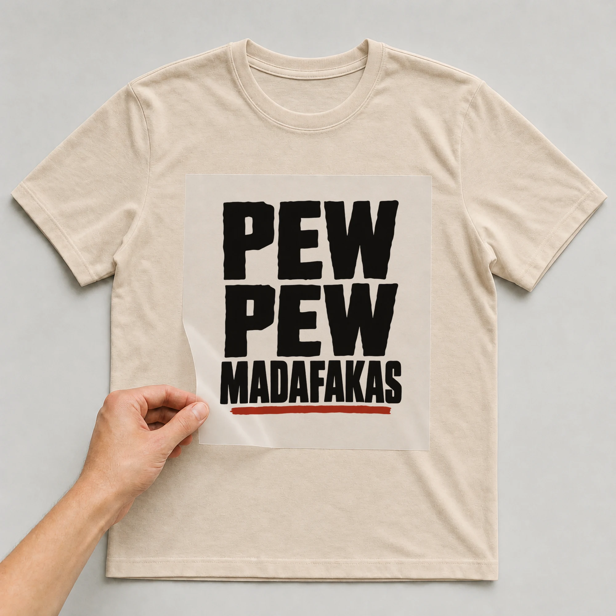 Bügelbild „PEW PEW MADAFAKAS“ auf babyblauem T-Shirt, Folie wird aufgelegt