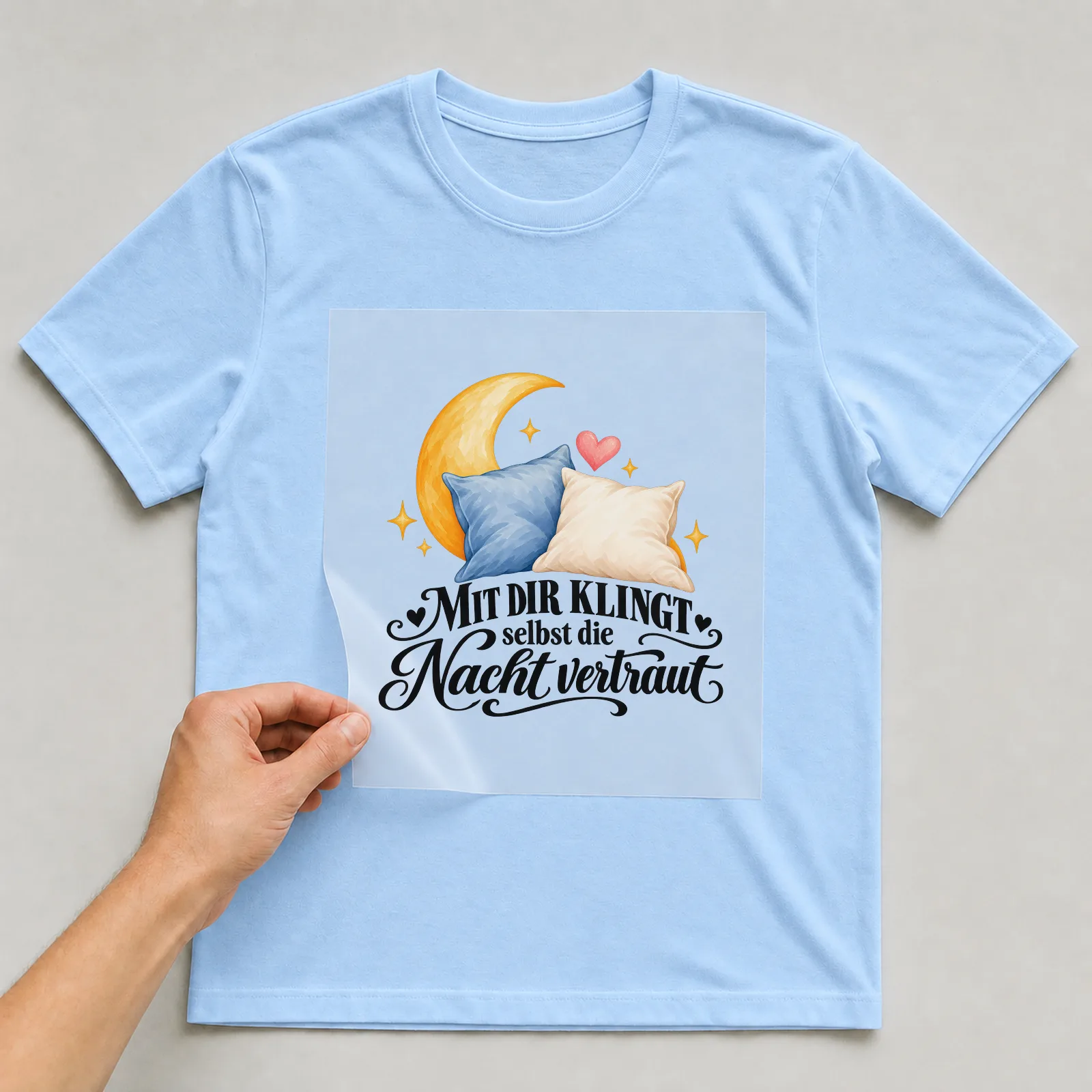 Bügelbild „MIT DIR KLINGT selbst die Nacht vertraut“ auf hellblauem T-Shirt, Folie wird aufgelegt