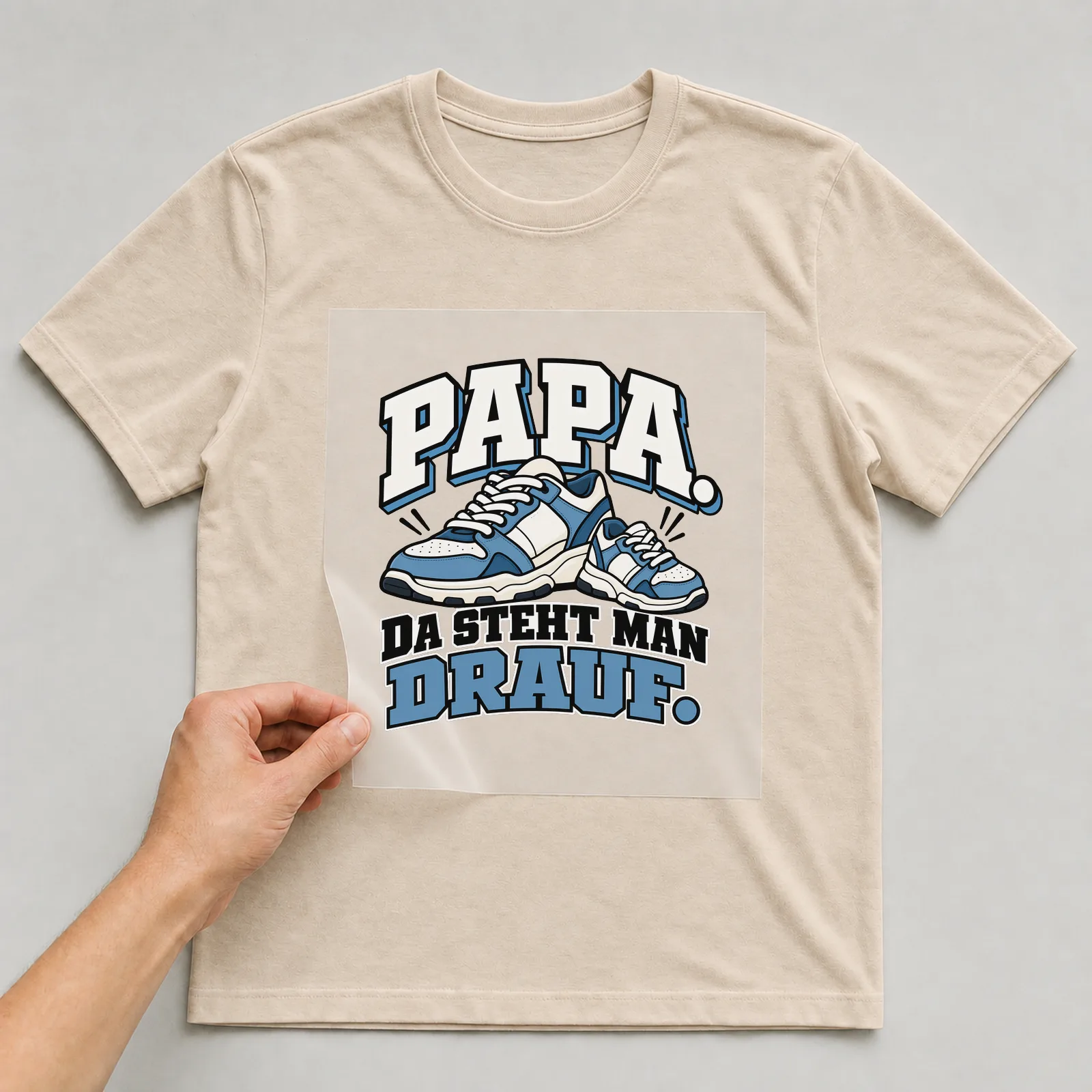 Bügelbild „Papa. Da steht man drauf.“ auf beigem T-Shirt, Folie wird aufgelegt