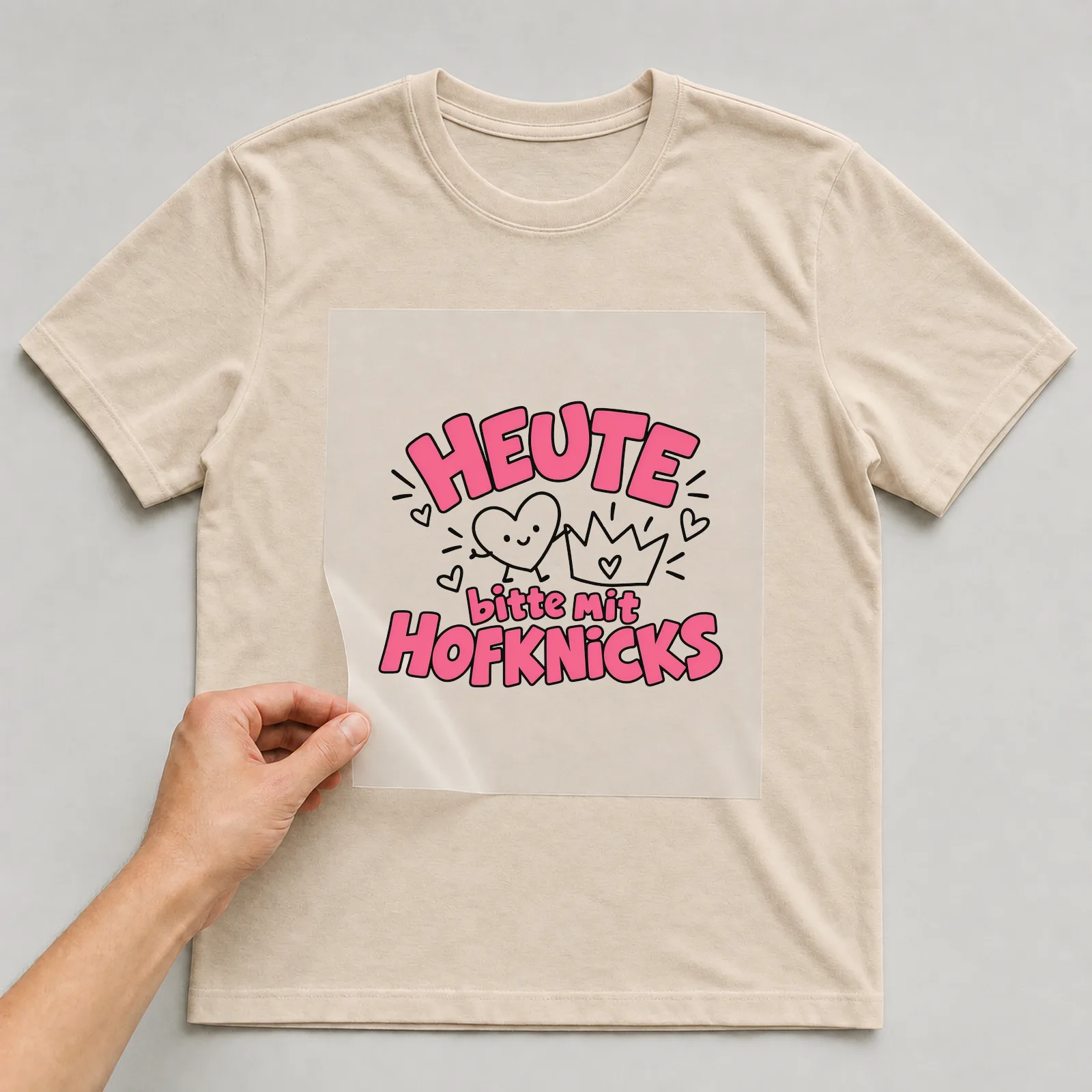 Bügelbild „Heute bitte mit Hofknicks“ auf beigem T-Shirt, Folie wird aufgelegt