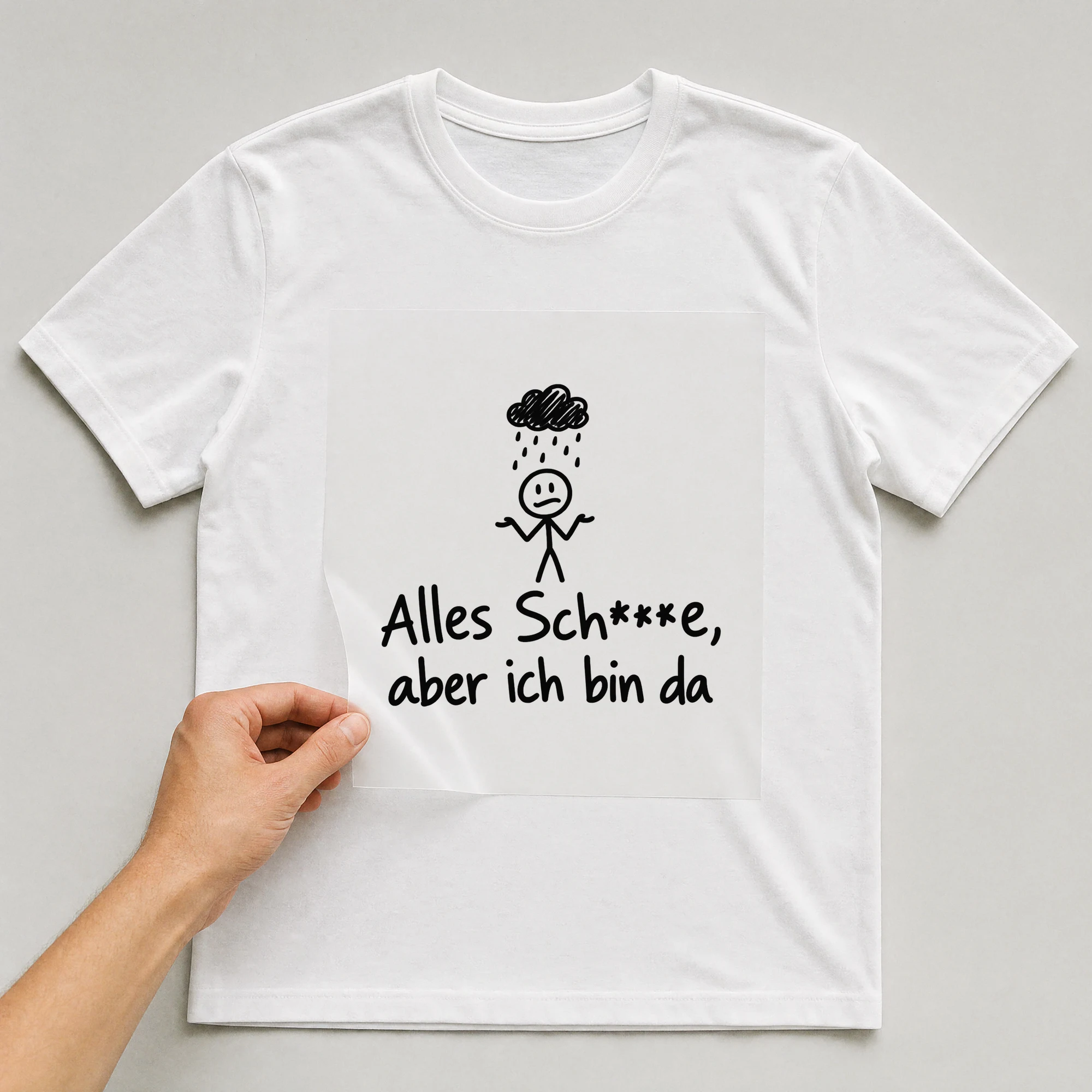 Bügelbild „Alles Sch***e, aber ich bin da“ auf weißem T-Shirt, Folie wird aufgelegt