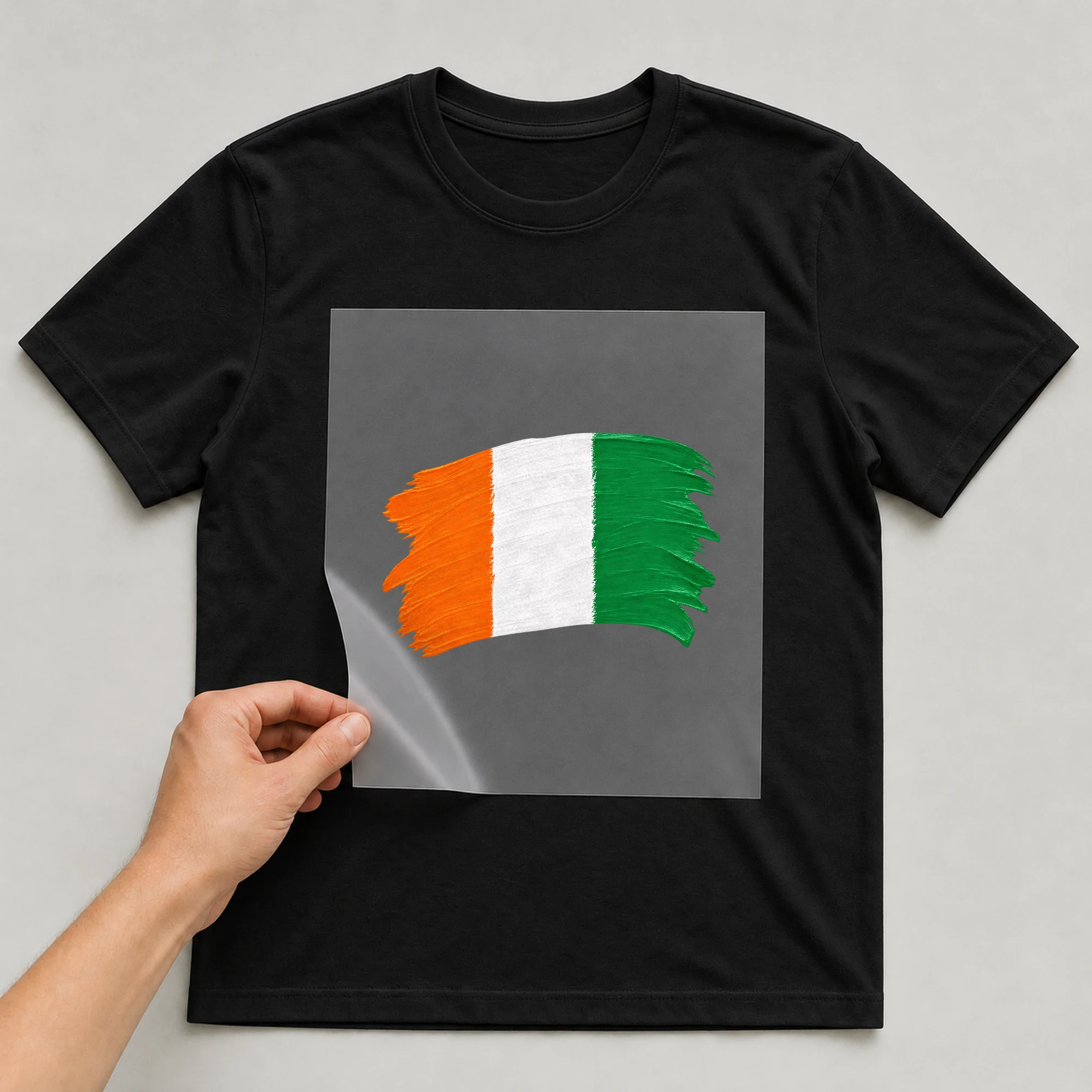 Bügelbild „BB021107-motiv-r03407“ auf schwarzem T-Shirt, Folie wird aufgelegt