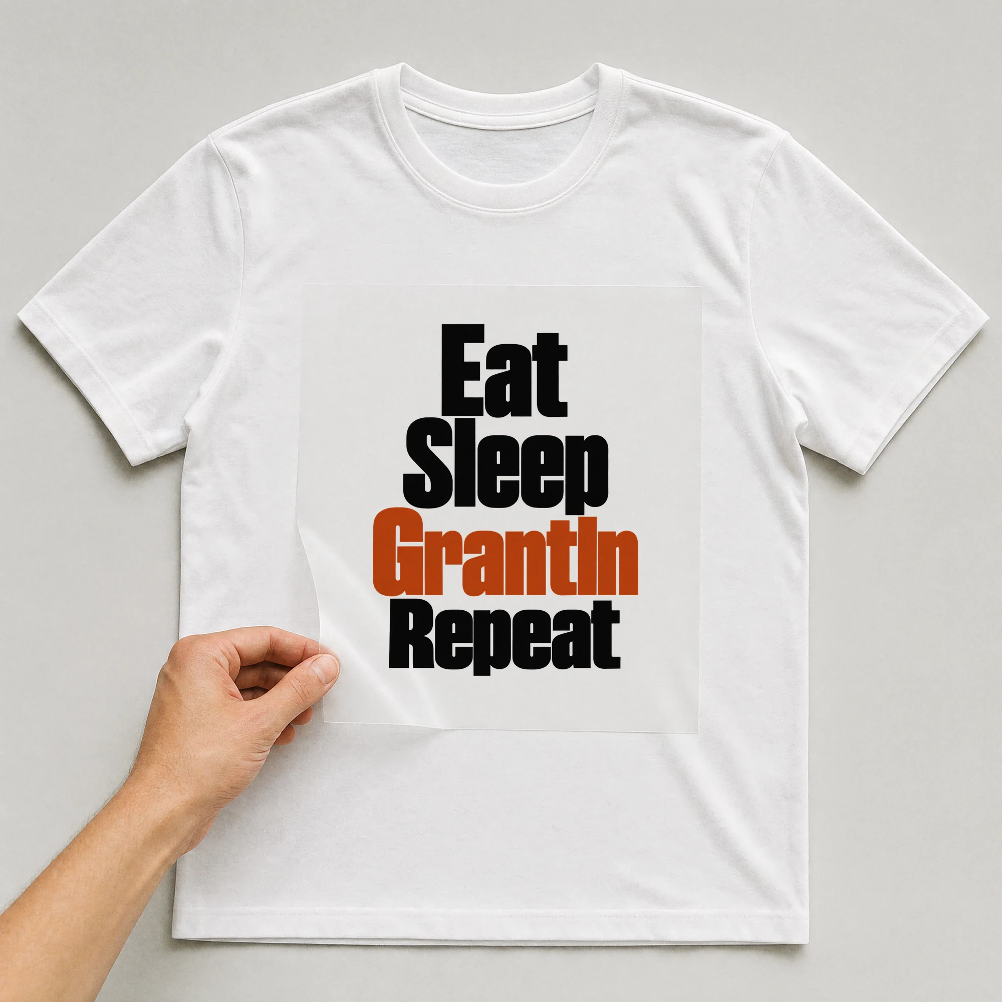 Bügelbild „Eat Sleep Grantln Repeat“ auf weißem T-Shirt, Folie wird aufgelegt