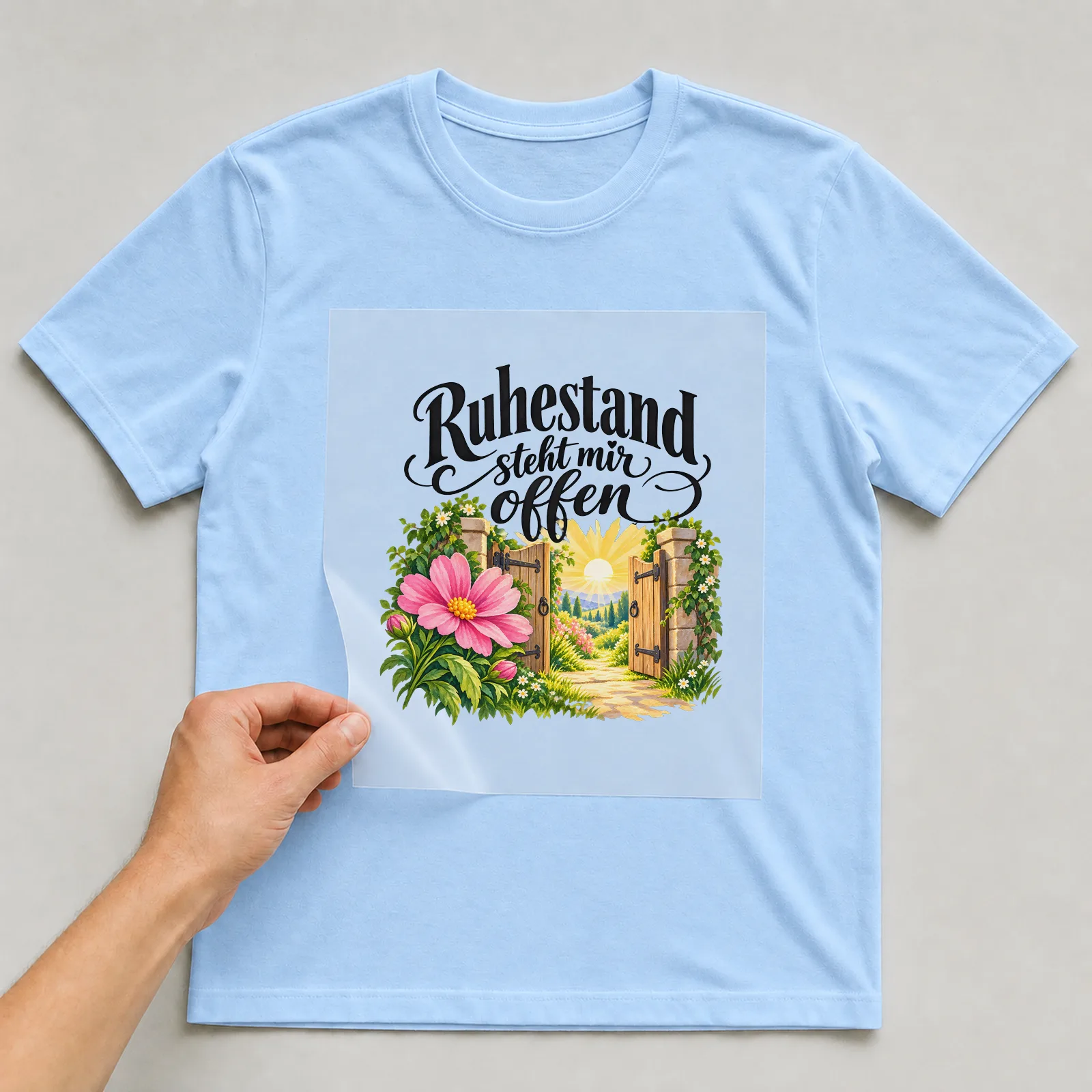 Bügelbild „Ruhestand steht mir offen“ auf hellblauem T-Shirt, Folie wird aufgelegt