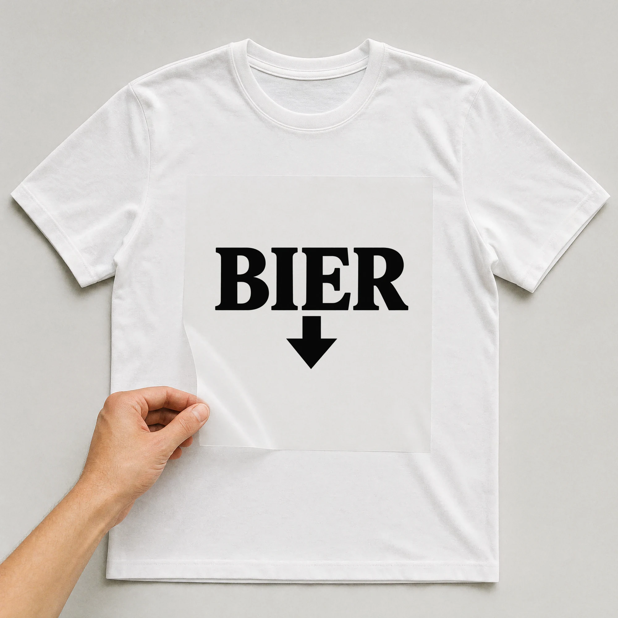 Bügelbild „Bier“ auf weißem T-Shirt, Folie wird aufgelegt