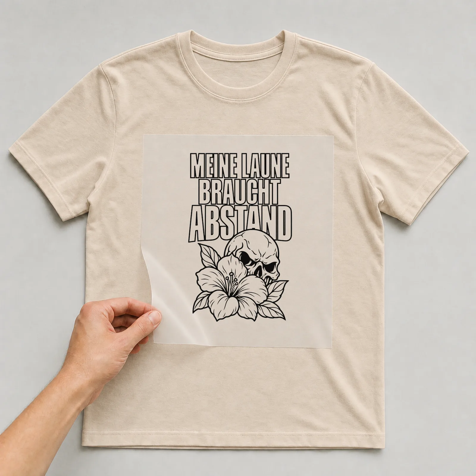 Bügelbild „Meine Laune braucht Abstand“ auf beigem T-Shirt, Folie wird aufgelegt