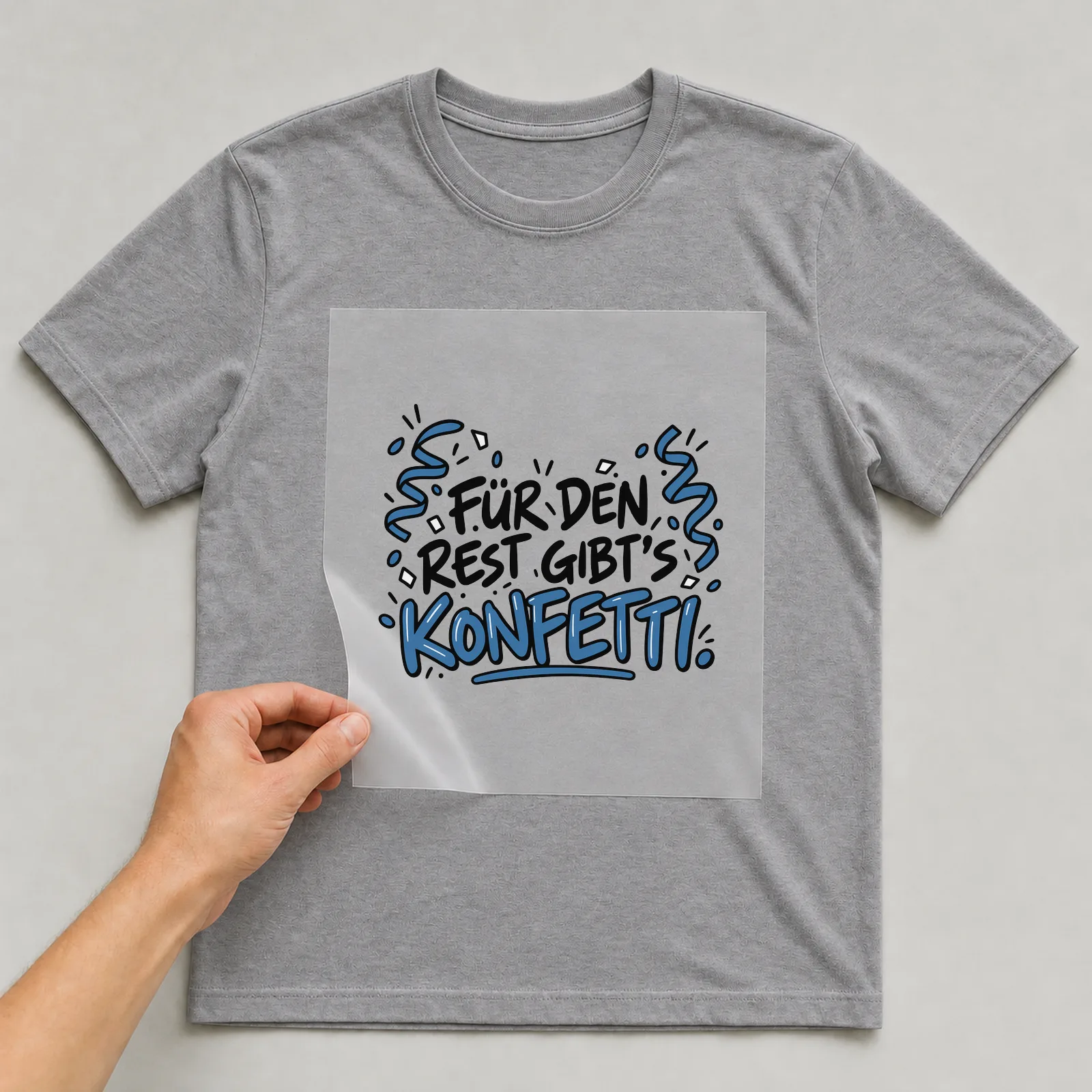Bügelbild „Für den Rest gibt's Konfetti“ auf grauem T-Shirt, Folie wird aufgelegt
