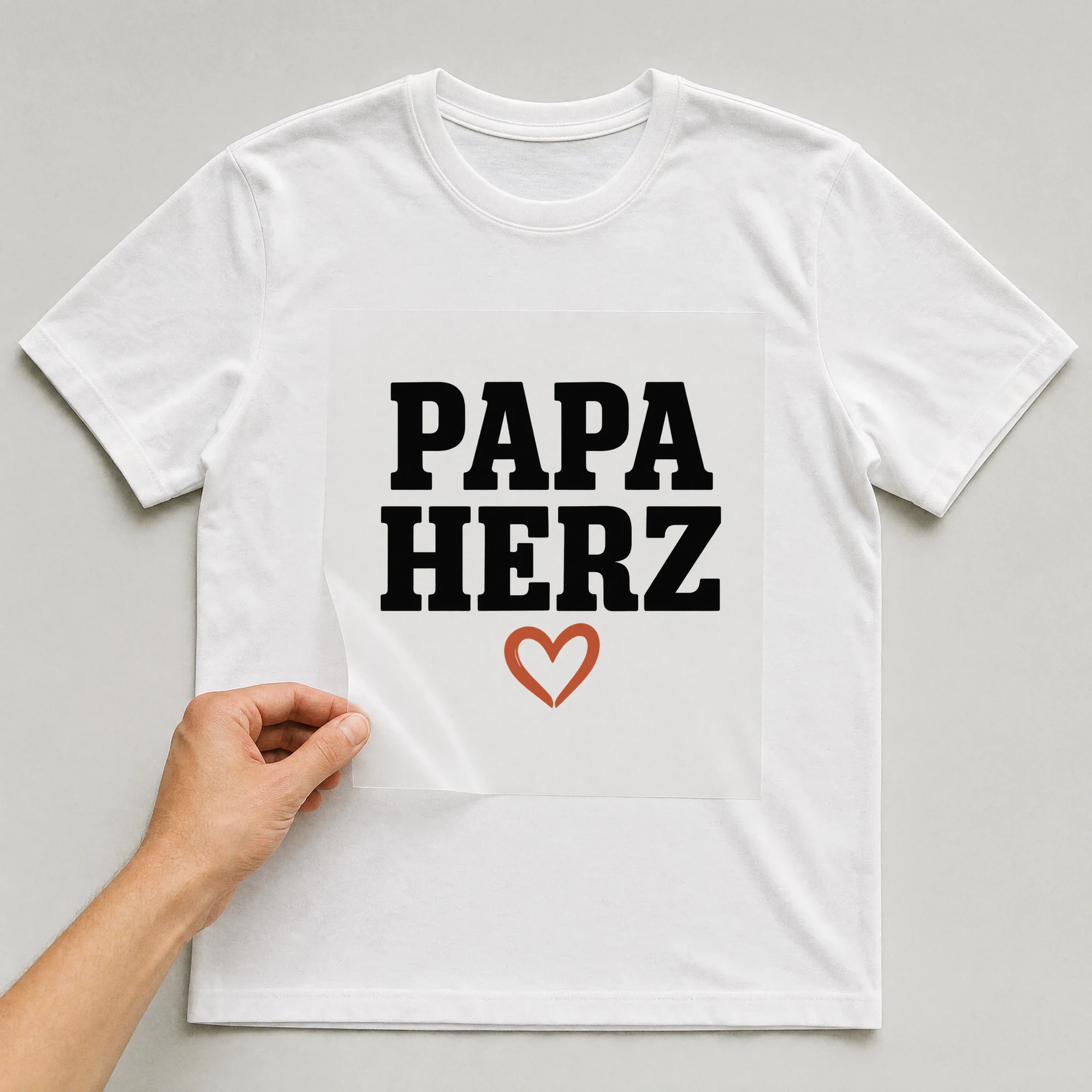 Bügelbild „Papa Herz“ auf weißem T-Shirt, Folie wird aufgelegt