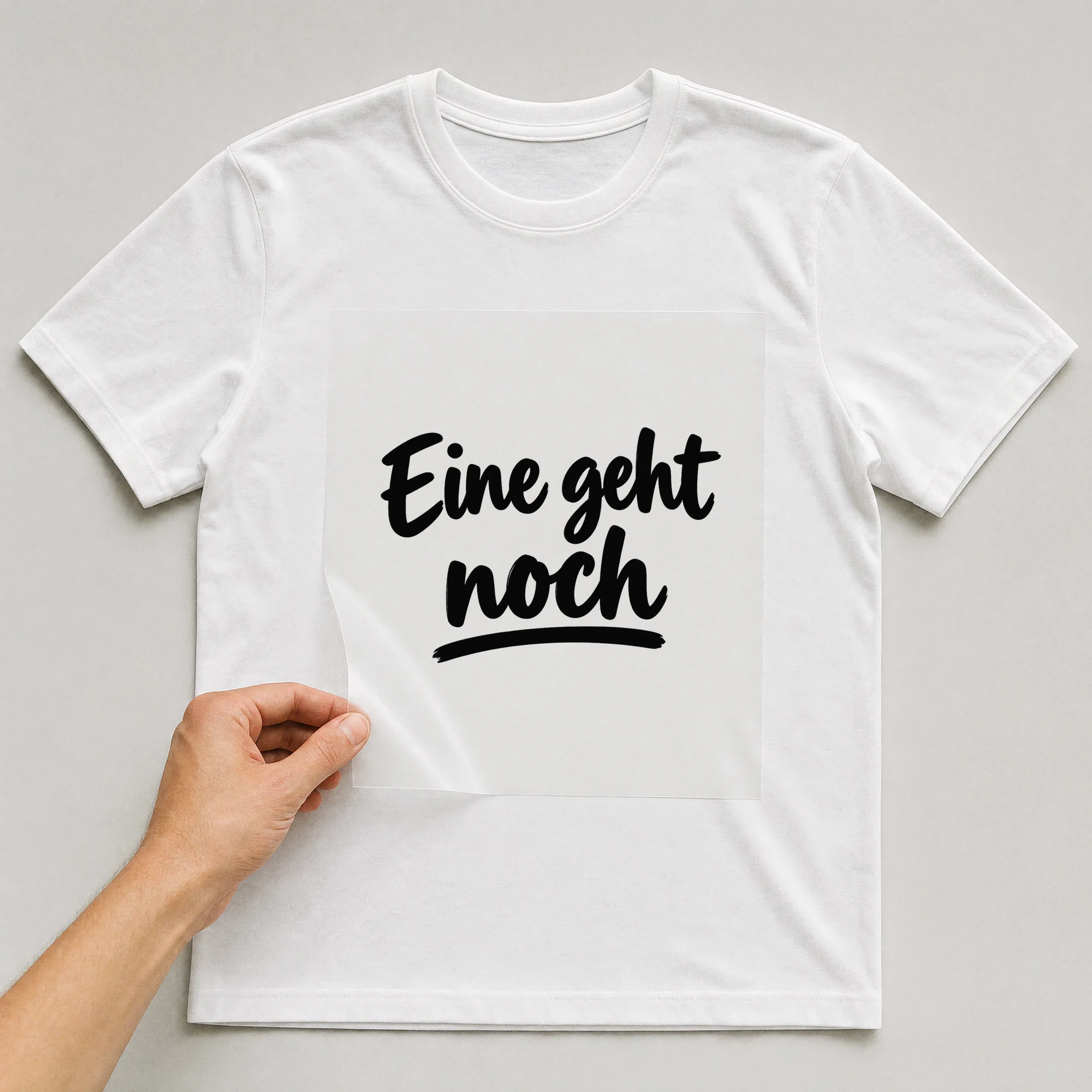 Bügelbild „Eine geht noch“ auf weißem T-Shirt, Folie wird aufgelegt