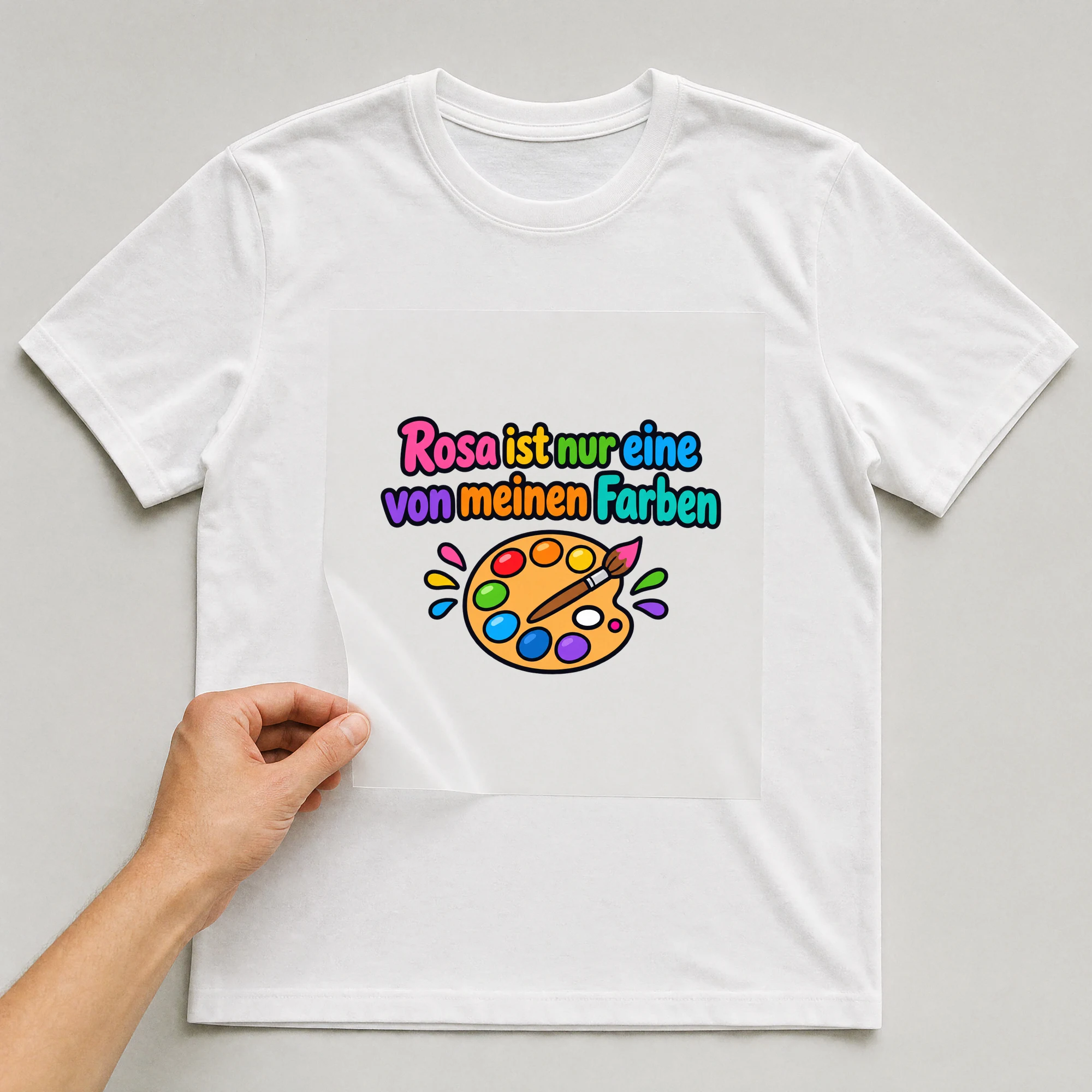 Bügelbild „Rosa ist nur eine von meinen Farben“ auf weißem T-Shirt, Folie wird aufgelegt