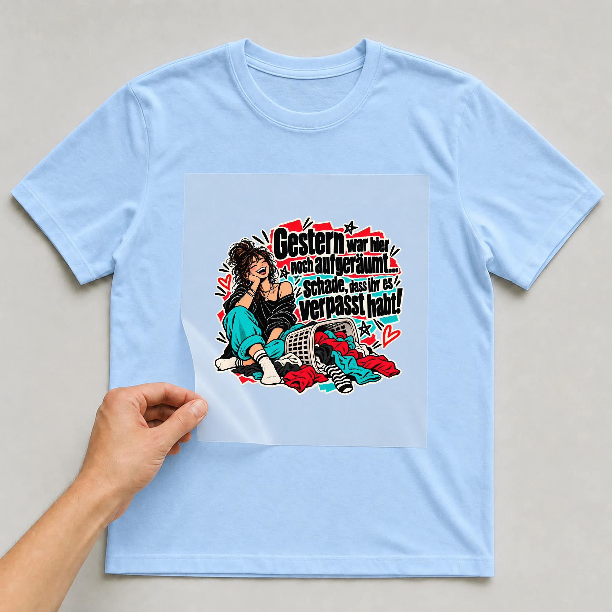Bügelbild „Gestern war hier noch aufgeräumt.“ auf babyblauem T-Shirt, Folie wird aufgelegt