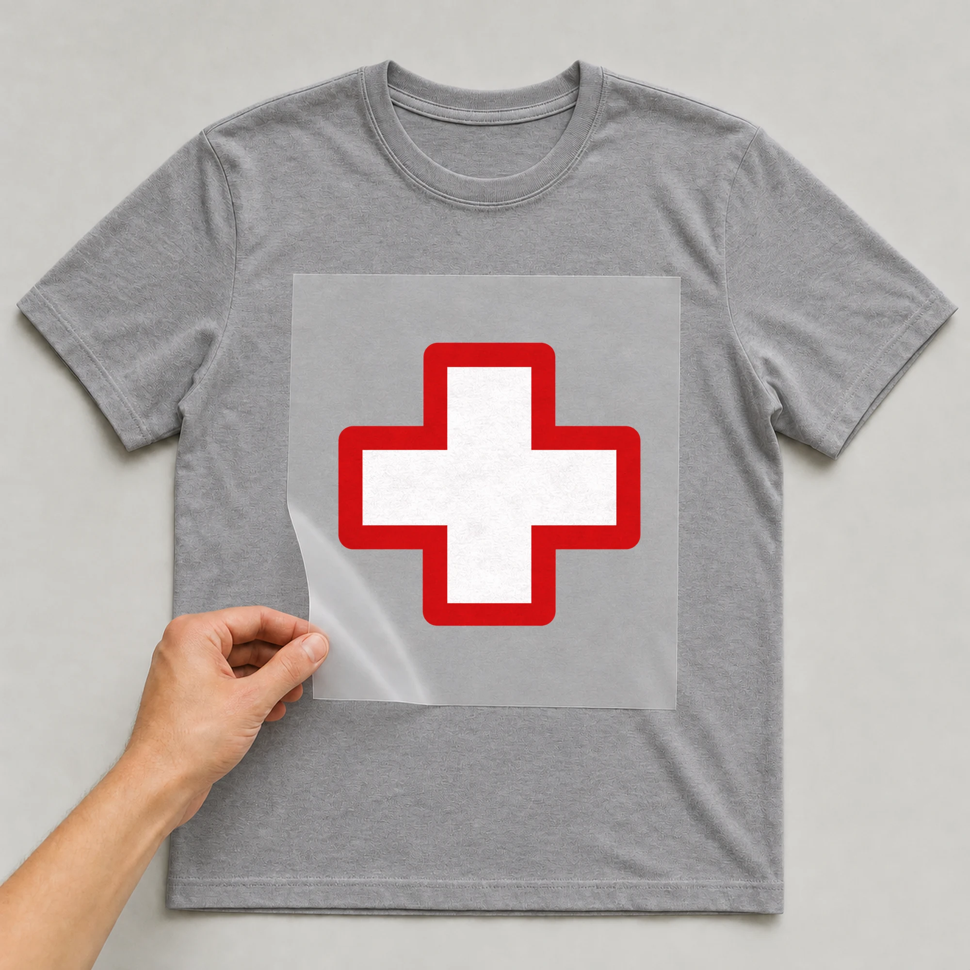Bügelbild „Schweiz Kreuz“ auf grauem T-Shirt, Folie wird aufgelegt