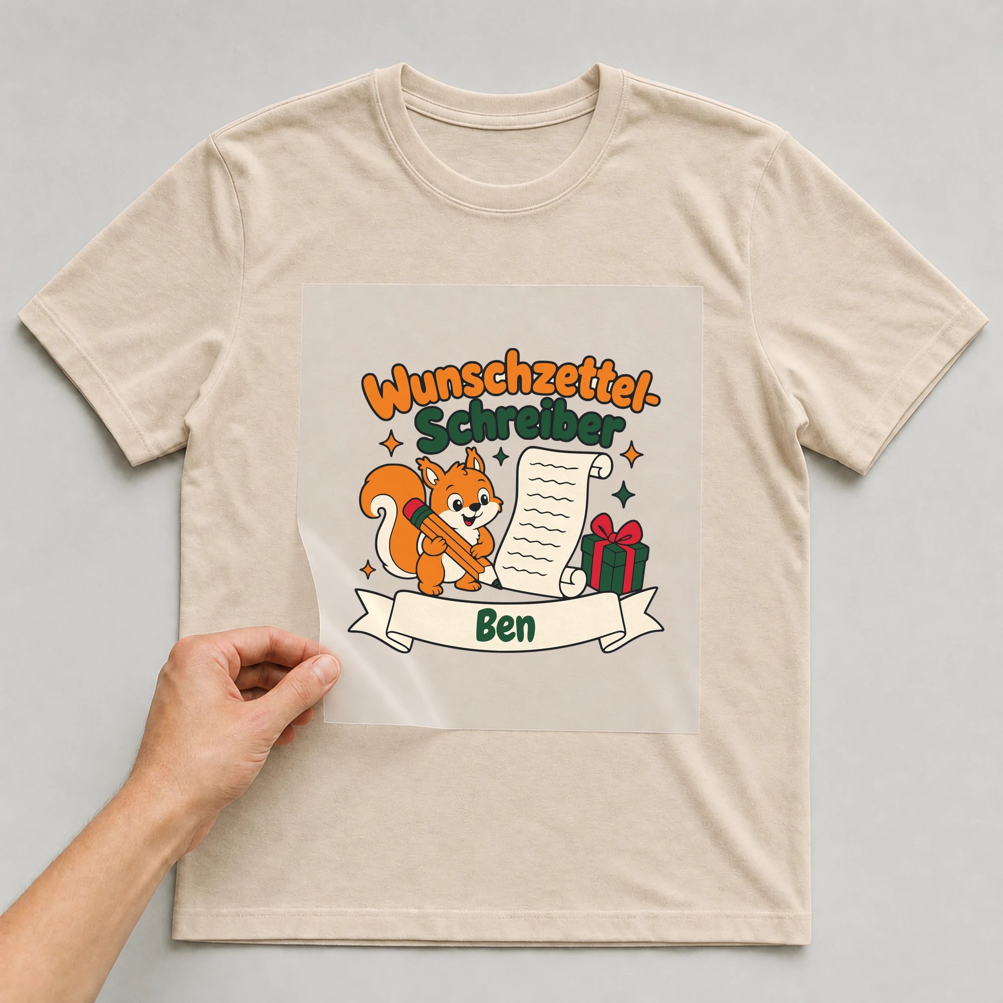 Bügelbild Wunschzettel-Schreiber mit Name auf beigem T-Shirt, Folie wird aufgelegt